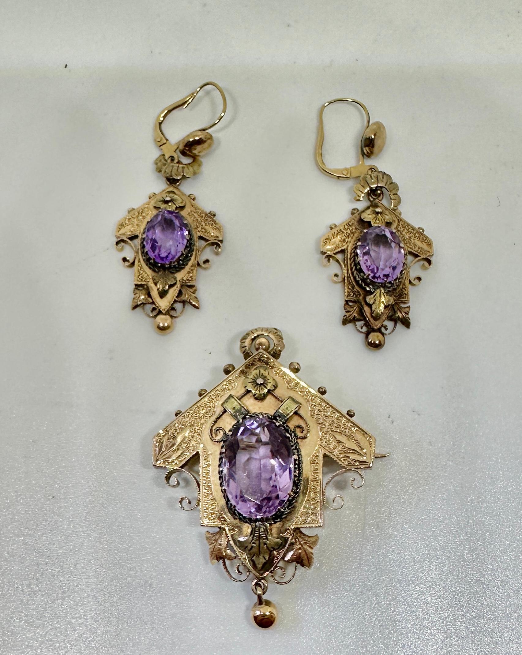 THIS IS A STUNNING ANTIQUE VICTORIAN AMETHYST EARRINGS AND PENDANT NECKLACE OR BROOCH PARURE SET IN GORGEOUS ENGRAVED GOLD WITH A FLOWER MOTIF AND DATING TO CIRCA 1870.
The gold is a gorgeous 10-14 Karat Gold.
The parure features stunning oval