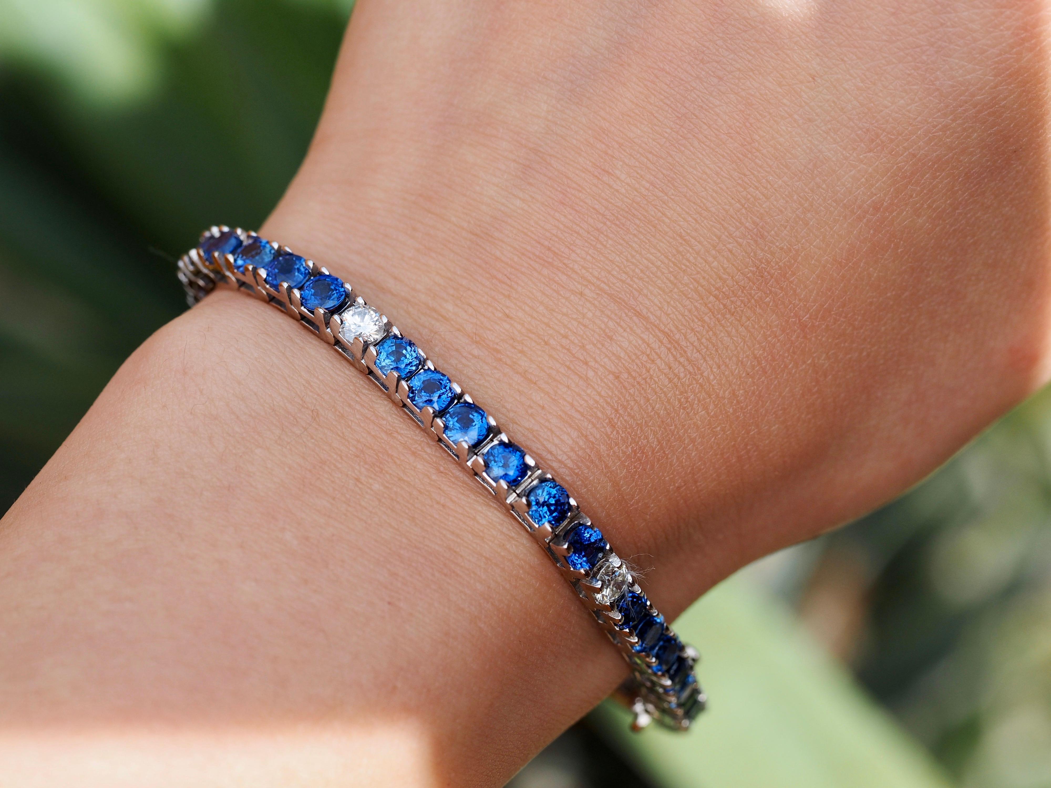 This incredible tennis bracelet is an absolute beauty. It is flowing with 12 carats of round, natural bright blue sapphires alternating with round brilliant diamonds in-between every sixth sapphire. The bracelet is made of 14- karat white gold and