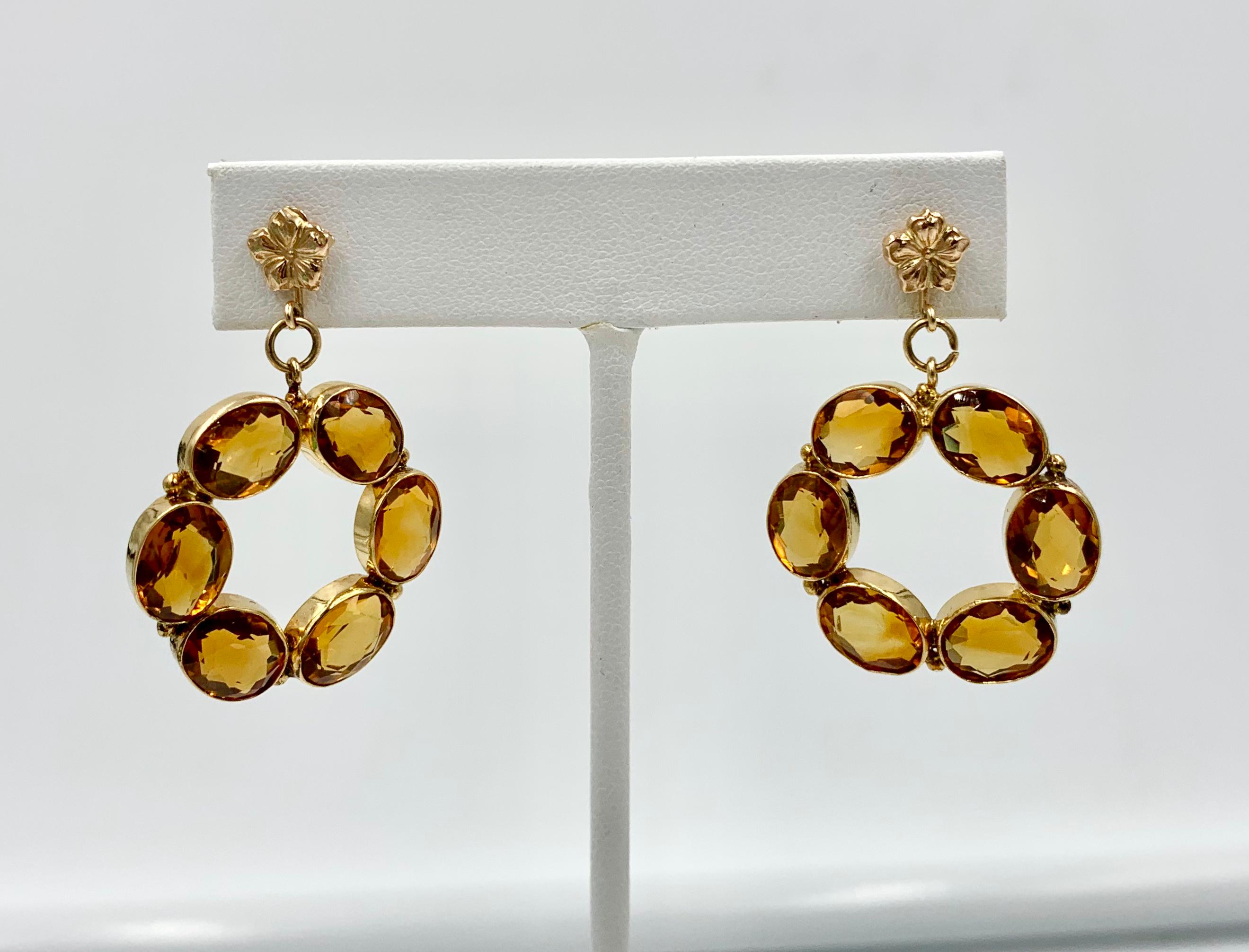 A stunning pair of Retro Citrine Earrings with 12 Oval Faceted Citrine gems of great beauty set in a circle and hanging from a flower medallion.  The gorgeous gems total approximately 12 Carats and are sparkling radiant Citrines.  The wonderful open
