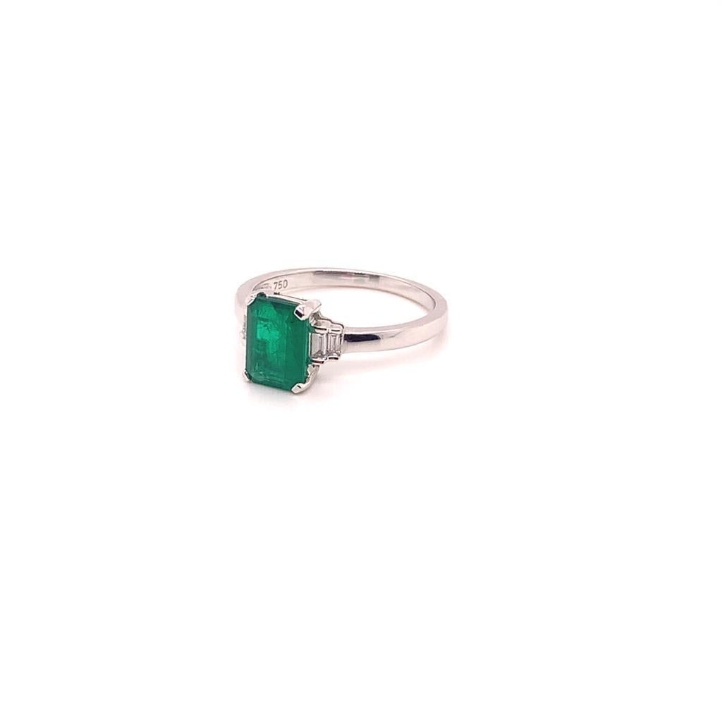 The Stunning Emerald cut Emerald that is at the centre of this exquisite ring weighs approximately 1.20 Carats and has 2 Baguette cut Diamonds on either side of it, the glittering diamonds weighing a total of approximately 0.11 Carats. Set in 18K