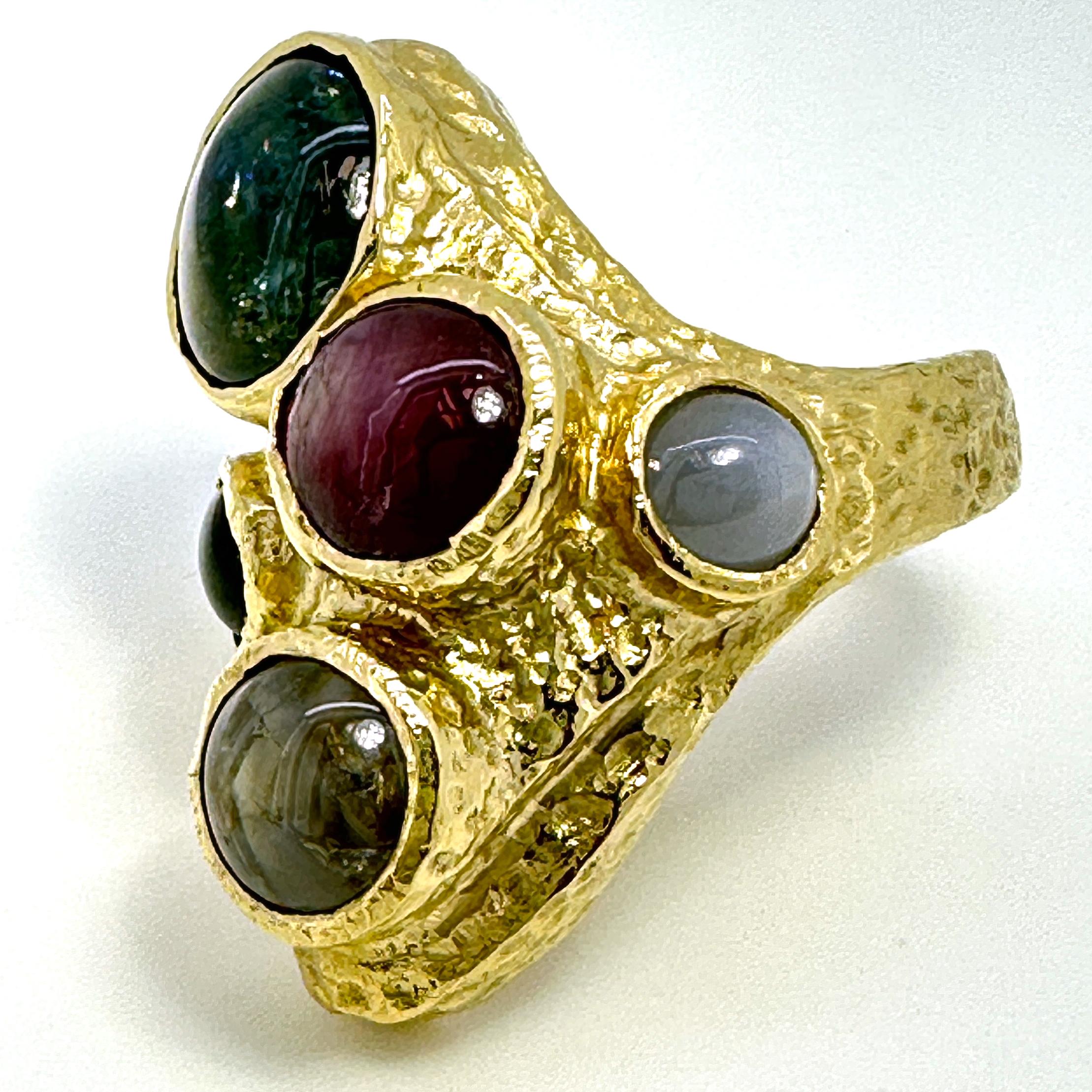 This one-of-a-kind ring by Eytan Brandes features five natural sapphire and ruby cabochons, each with interesting color and light characteristics.

The magenta-colored stone is a 2.94 carat star ruby from Madagascar.  In the right light, it shows a