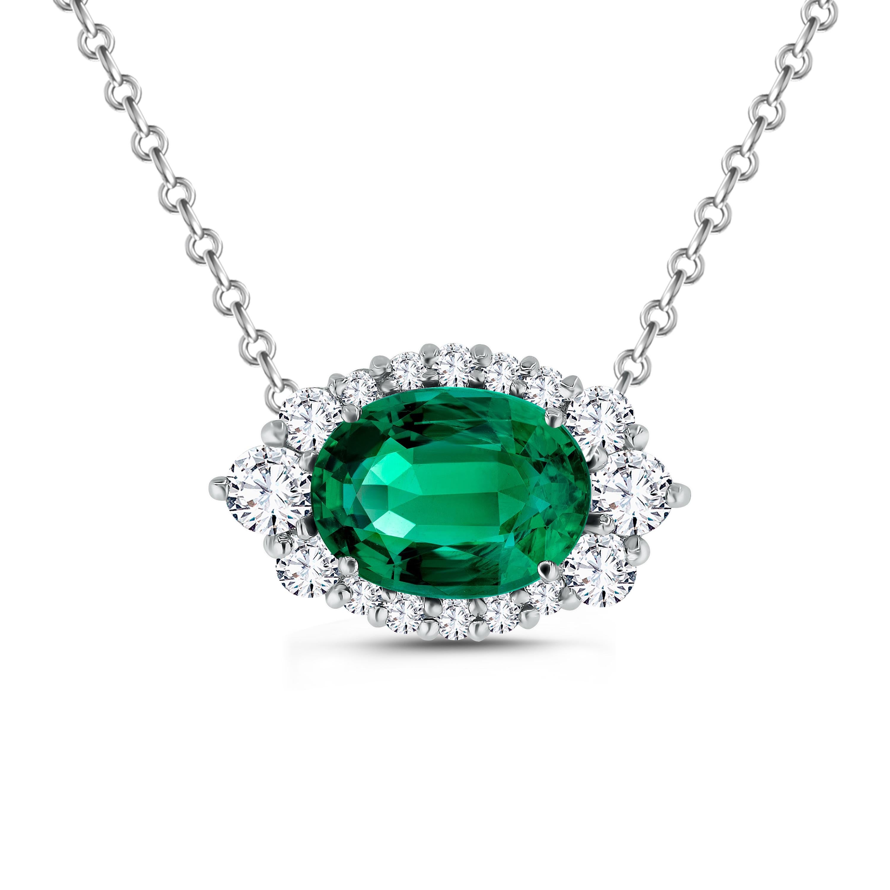 Radioso e raffinato, questo squisito pendente mette in mostra un vivido smeraldo di 8x6 mm dal taglio ovale circondato da una scintillante aureola di diamanti graduati dal taglio a brillante. Il verde lussureggiante dello smeraldo è perfettamente
