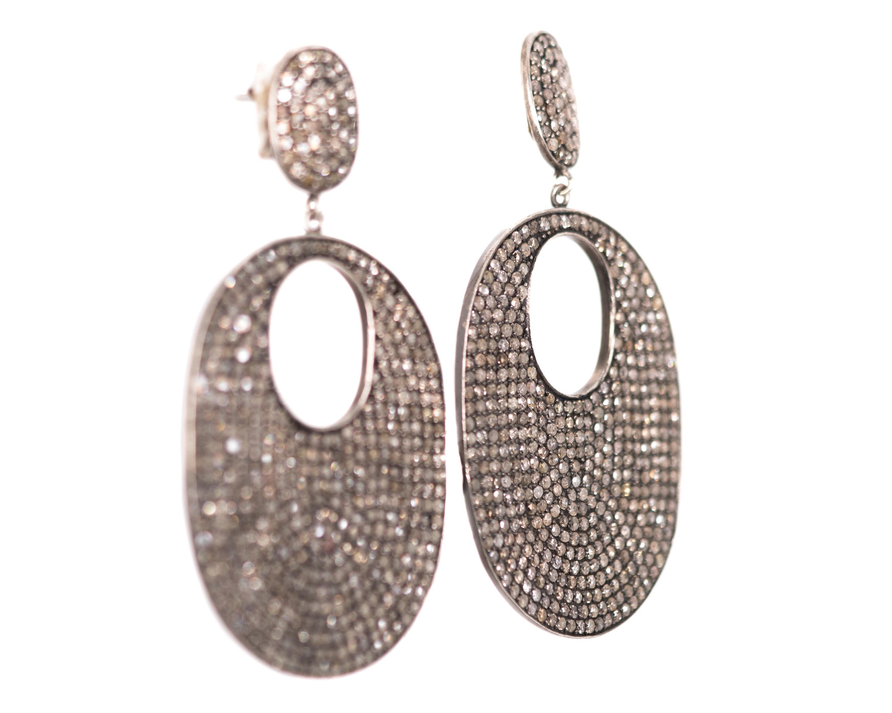 Diamond Dangle Earrings - Sterling Silver, Diamonds

Features:
12.0 carats total weight prong set Diamonds
Sterling Silver 
Friction post with wide, stabilizing push backs 
Oval shaped post earring with hinged, dangling lower oval 
2.75 inches long