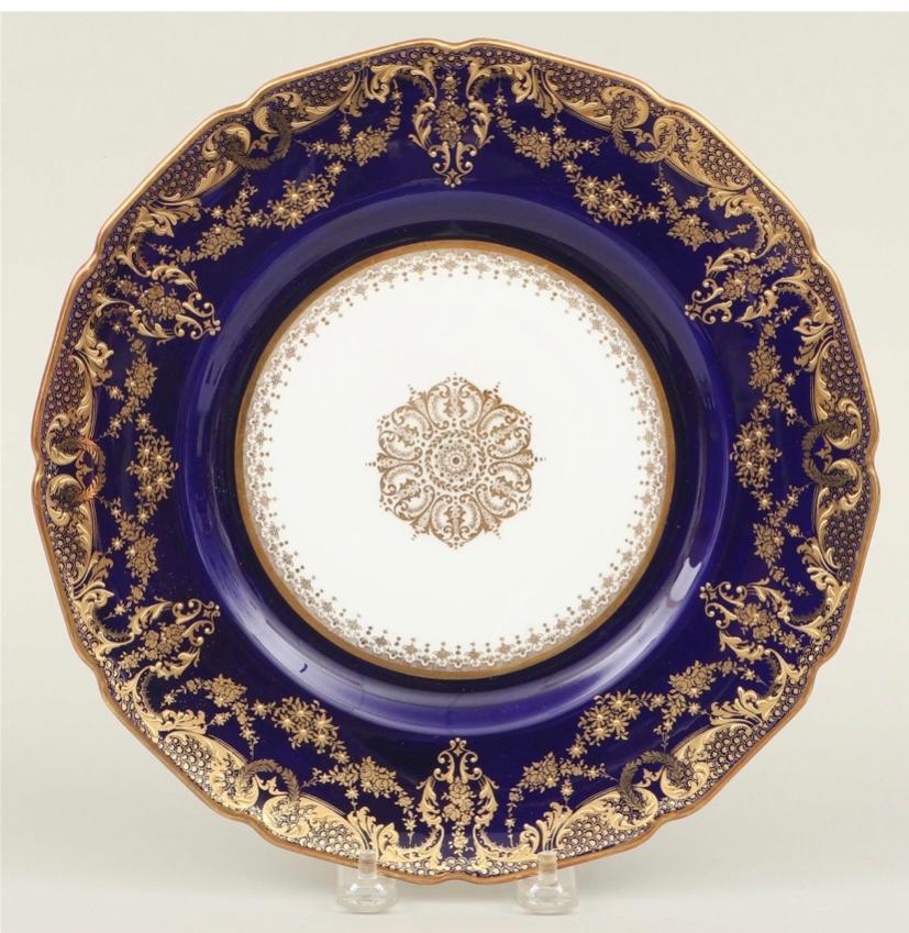 A striking and elegant set of twelve dinner plates by one of our favorite Gilded Age firms, Royal Doulton England. This set features their classic Robert Allen shape with a wide collar of cobalt blue and decorated with rich and intricate raised