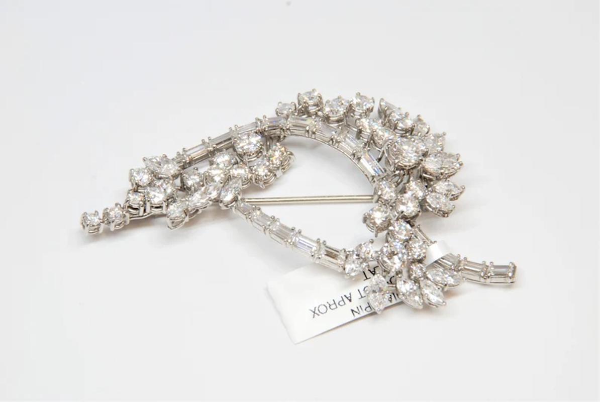 This antique brooch features round, marquise, and baguette shape diamonds weighing approximately 12 ct. They are graded E-F, VS1-VS2 and set in platinum. 

