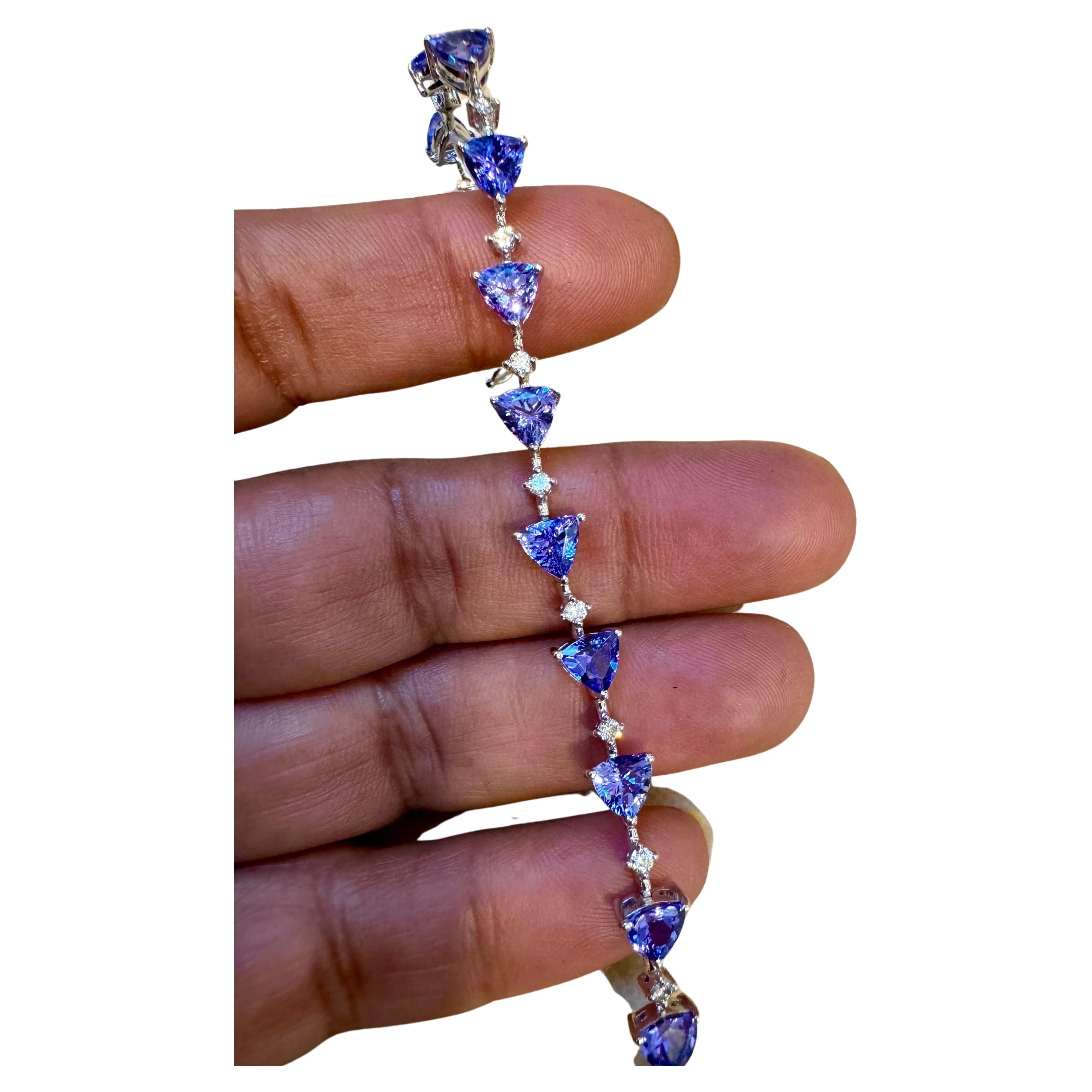 This stunning Tennis bracelet features multiple Trillion Tanzanite stones. With a total of 16 trillion tanzanites weighing approximately 12 carats, it exudes elegance. Complementing the tanzanites are 15 diamonds weighing about 0.50 carats in