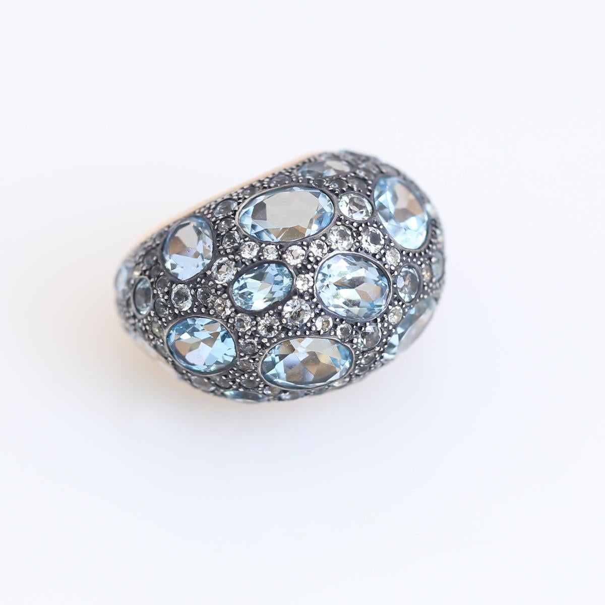 Sky Blue Topaz Ring by Pomellato Signed and in its Original Box. A magnificent bombe style ring by Pomellato. Showcasing 12 Ct of multiple shaped Topazes set in shimmering 18 Karat Rose Gold. The ring measures a size 6. Size can not be changed.