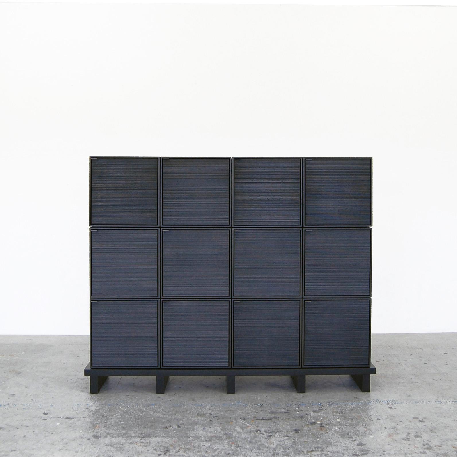 12 Cubes cabinet by John Eric Byers
Dimensions: D 150 x W 38 x H 122 cm
Materials: sawn + blackened + maple + brass

All works are individually handmade to order.

John Eric Byers creates geometrically inspired pieces that are minimal,