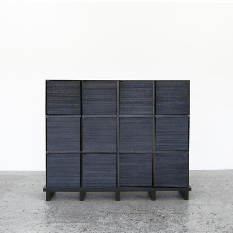 12 Cubes cabinet by John Eric Byers
Dimensions: D 150 x W 38 x H 122 cm
Materials: sawn + blackened + maple + brass

All works are individually handmade to order.

John Eric Byers creates geometrically inspired pieces that are minimal,
