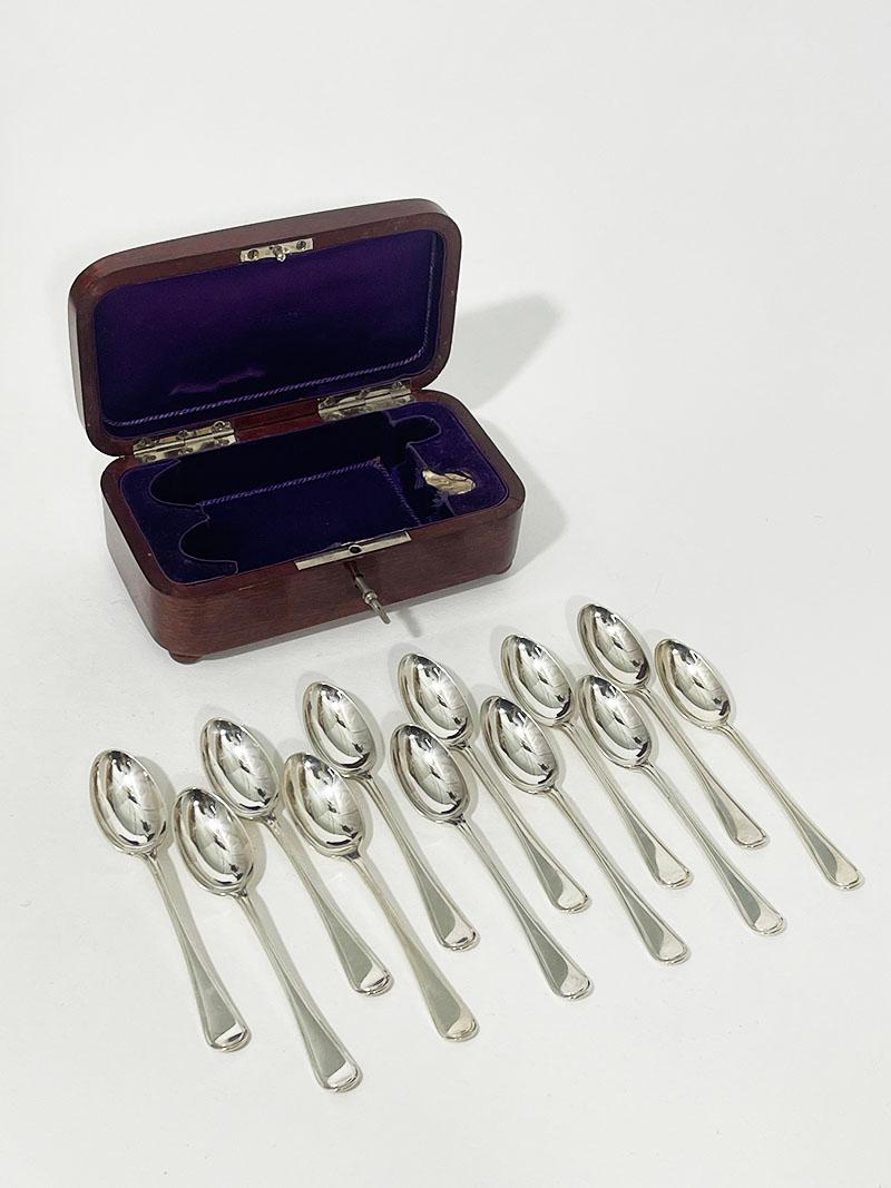 12 Dutch Silver tea spoons in box by Van Outvorst Junior & son Amsterdam 1917

Silver tea spoons in a cherry wood colored box with interior of purple valor and silk fabric
The lidded box  is rectangular and round curved edges, including working key