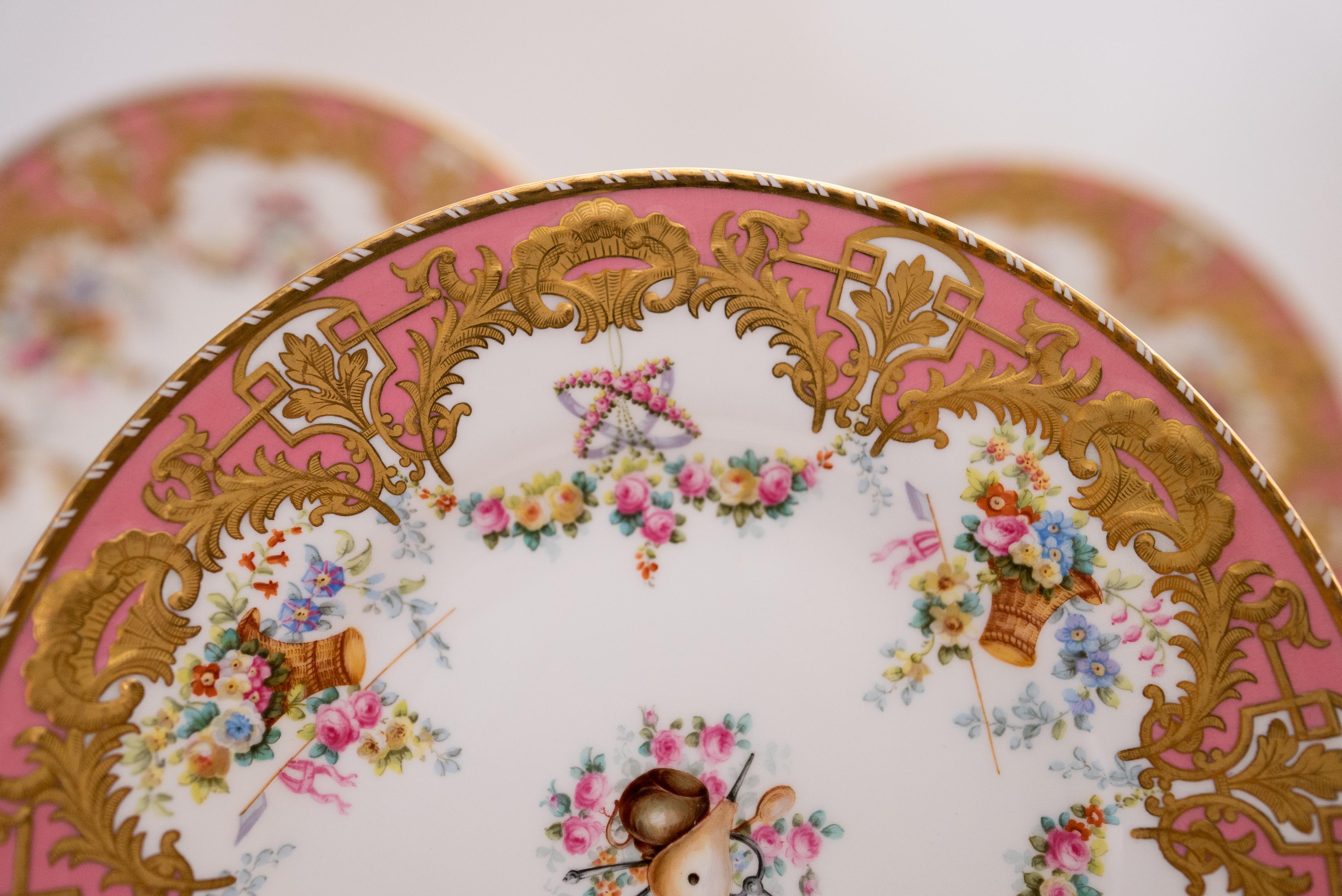 An elaborate set of plates by Copeland Spode, England. This design features a raised design of floral gilding throughout its pink collar. Hand painted designs, each plate different and also has central floral medallion. Custom ordered through the