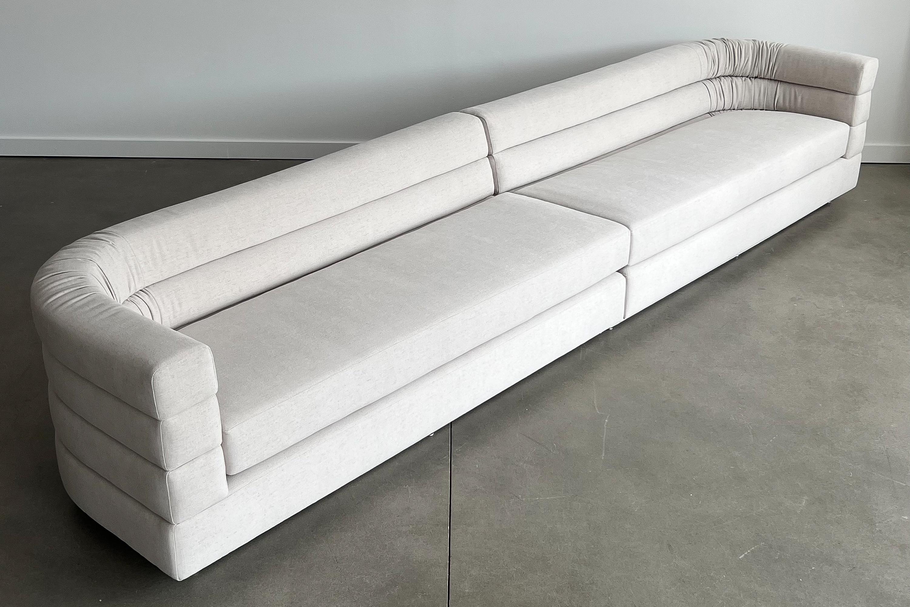 A dramatic 12 foot long two piece channeled sofa by Richard Himmel for Interior Crafts, circa 1970s. This sofa has been newly upholstered in a fine modern chenille fabric with all new foam throughout. The fabric is a pale bone color with gray