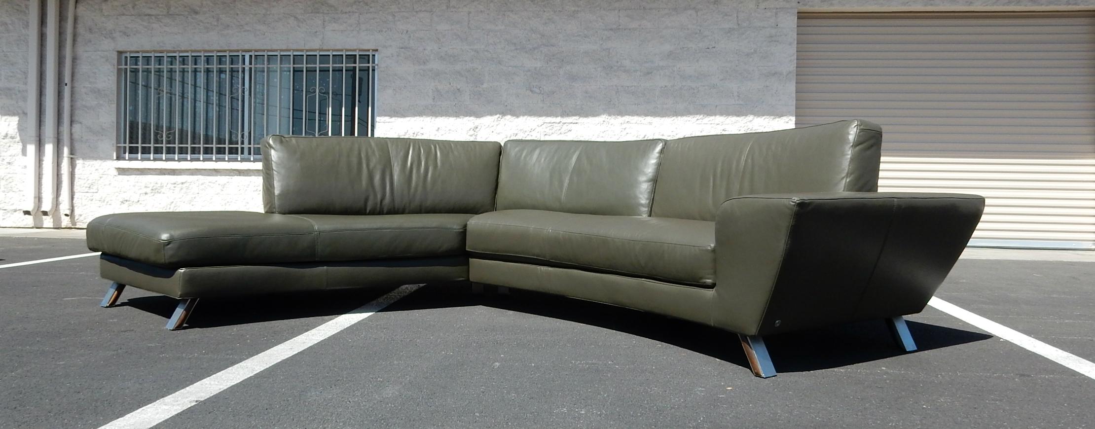 Dramatic 12 foot and long curved sectional sofa by Natuzzi of Italy with matching diamond shape ottoman.
Premium buttery soft Loden green leather upholstery with brushed aluminum legs trimmed in centre with wood.
Exceptionally comfortable seating