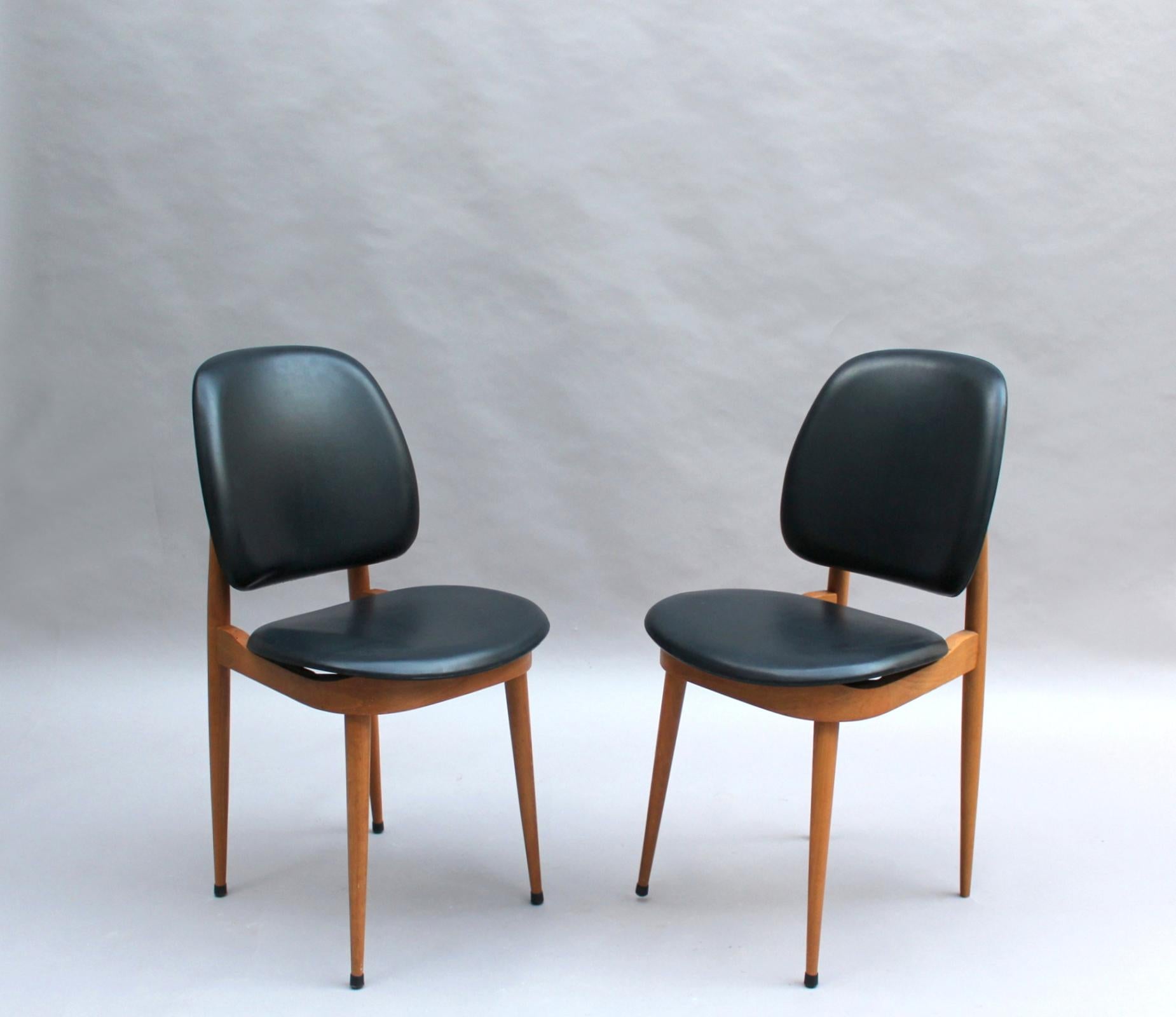 12 chaises de salle à manger françaises du milieu du siècle en hêtre et naugahyde attribuées à Pierre Guariche, modèle Pégase, édité par Baumann.

Le prix est par chaise.