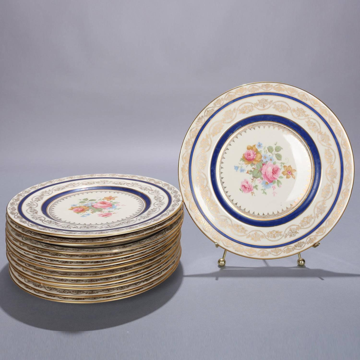 Set of 12 porcelain plates by Transulcent China dinner plates feature central rose floral bouquet with 22-karat gold gilt foliate filigree rim and having cobalt blue, 20th century

Measures: .75
