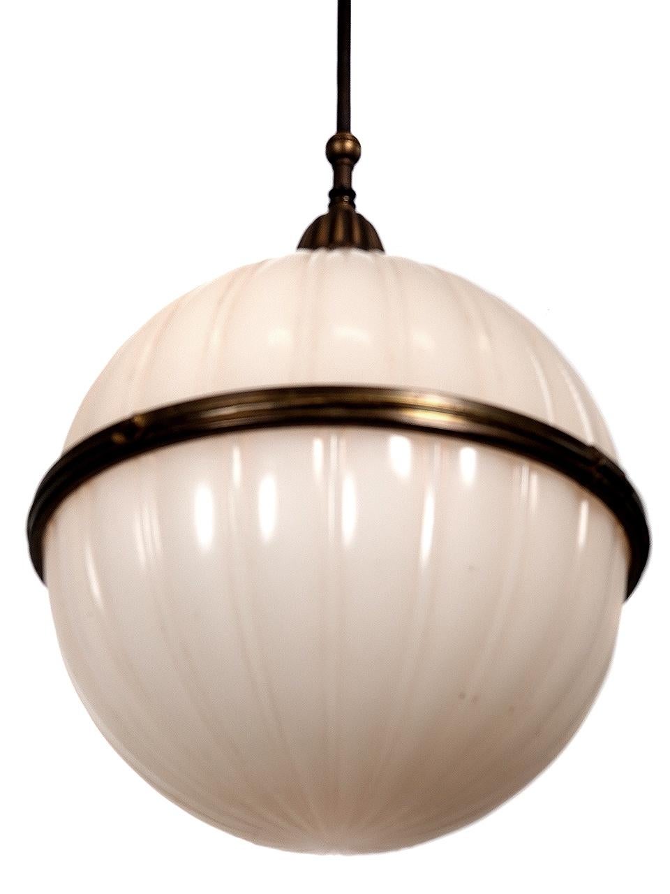 This large lamp is called a Split Globe because it is hinged in the center and opens to easily change the light bulb. The horizontal brass ring also adds to the lamps interest. The decorative and heavy cast brass crown also adds to the lamps unique
