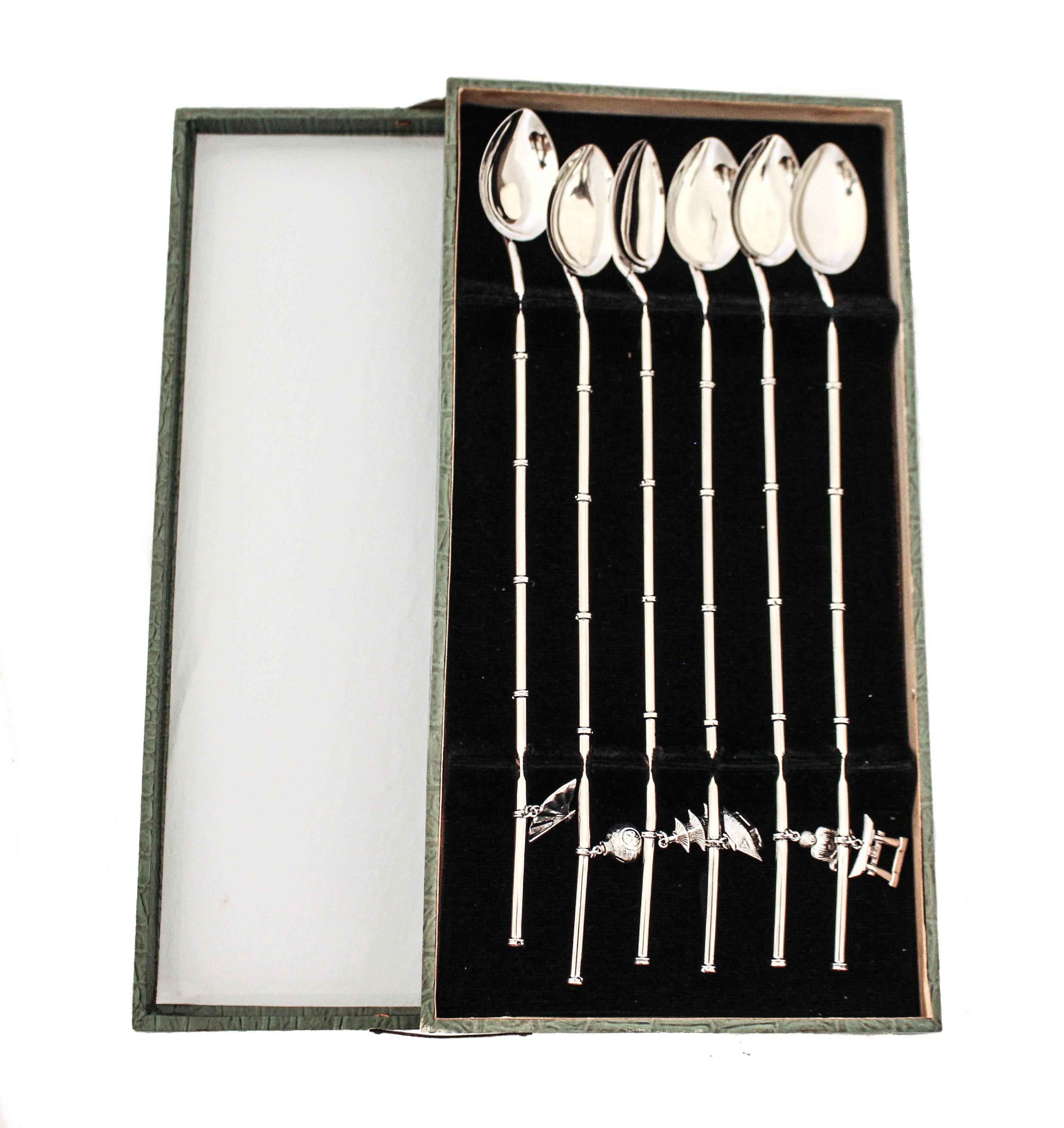 Se ofrece un juego completo de doce cucharas de té helado / julepe de menta. Cada juego de seis viene en el estuche original. El maletín tiene bisagras en el lateral y una ranura para que cada cuchara individual encaje. En consonancia con el tema