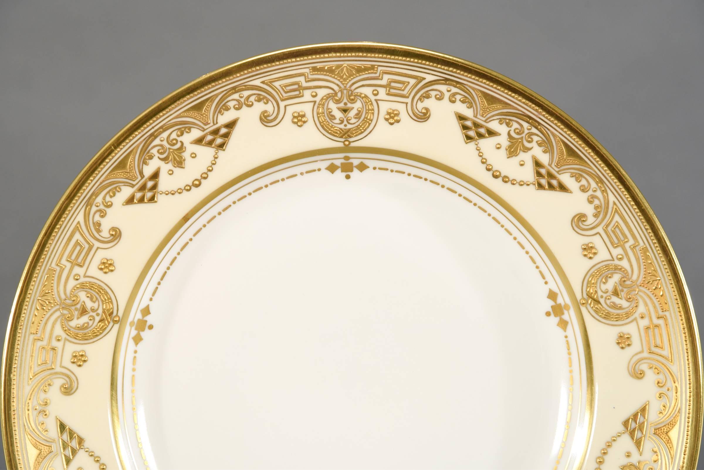 This set of 12 dinner plates are made by the iconic Ambrosius Lamm Dresden in a rare Arts & Crafts style decoration featuring a clear white center, framed with an ivory border. It is further embellished with an unusual raised paste gold motif and