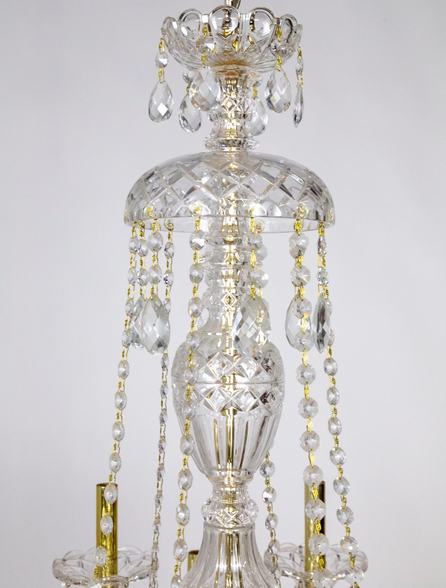 A 12-arm, 2-tier chandelier made of Bohemian molded glass that creates intriguing texture. With crystal beaded garlands and reflective, gold toned candle covers. 1970s. Measures: 45” height x 30” diameter.
