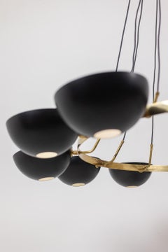 12-light chandelier in patinated brass and black lacquered metal. Contemporary