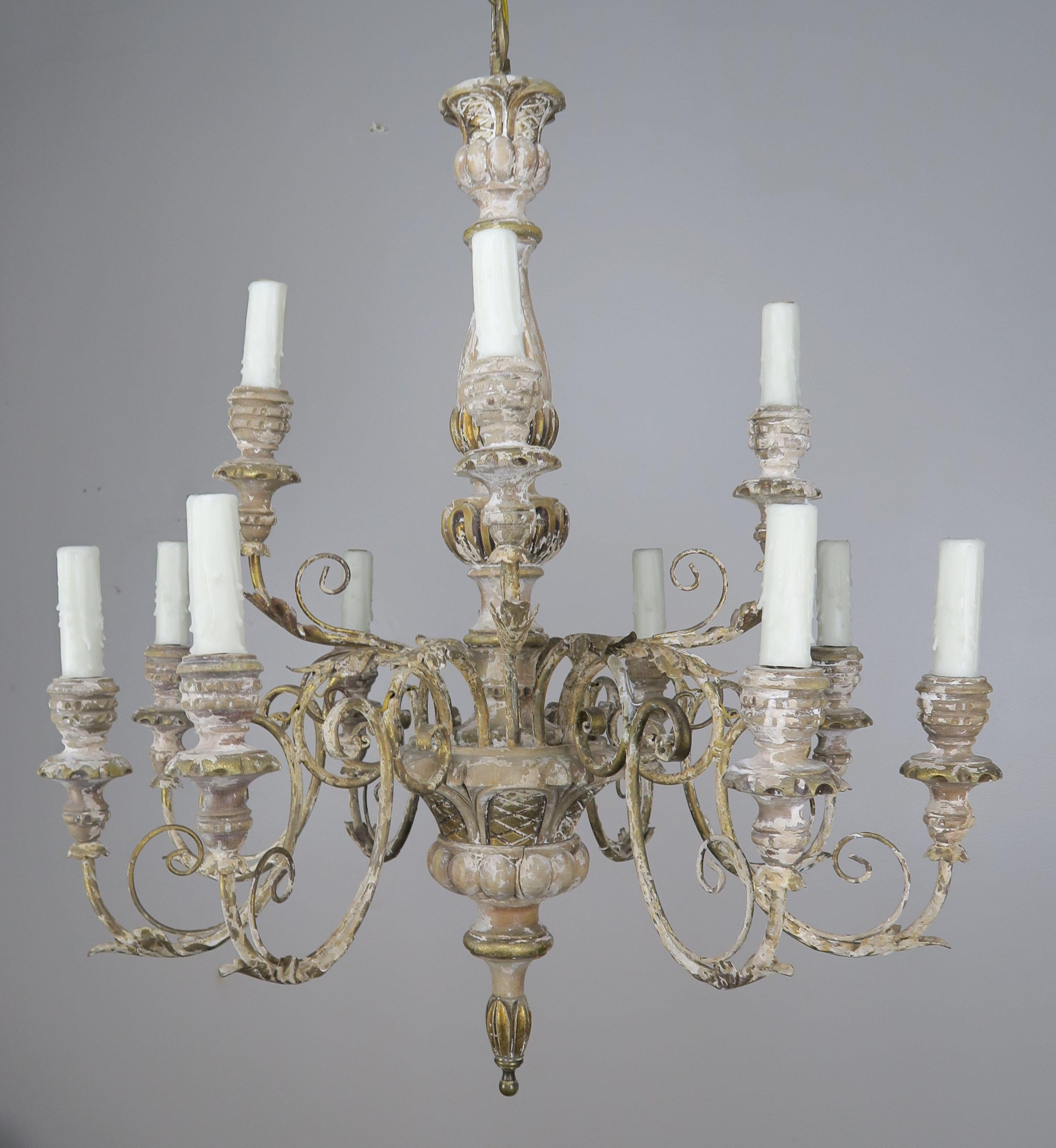 ‘12’ light French painted and parcel gilt carved wood and iron chandelier. The chandelier is newly rewired with drip wax candle covers. Includes chain and canopy.