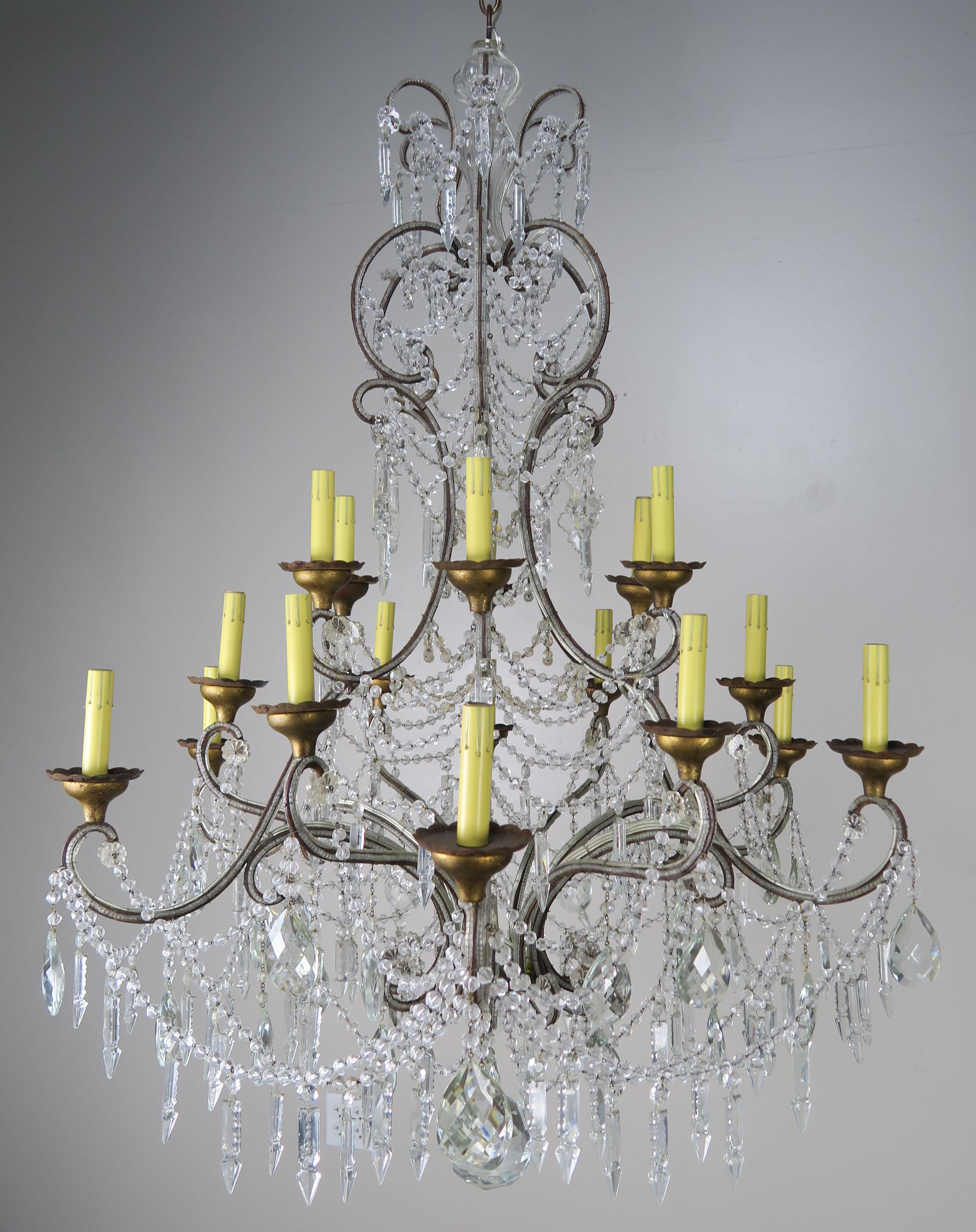 Twelve light monumental Italian crystal beaded chandelier adorned with English cut beaded garlands, almond shaped faceted crystals and crystal spheres throughout. The fixture has been newly rewired with candle covers. The candle covers appear more