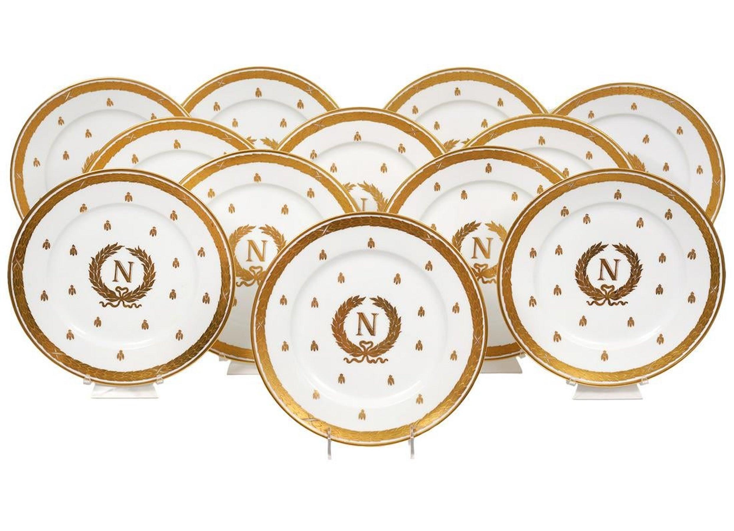 12 vergoldete, emaillierte napoleonische Teller aus Limoges, um 1900, jeder mit vergoldetem Lorbeerkranz, gefüllt mit goldenen Bienen, in der Mitte ein napoleonisches Wappen mit Lorbeerkranz und monogrammiertem 'N'.
Das Porzellan wurde von Charles