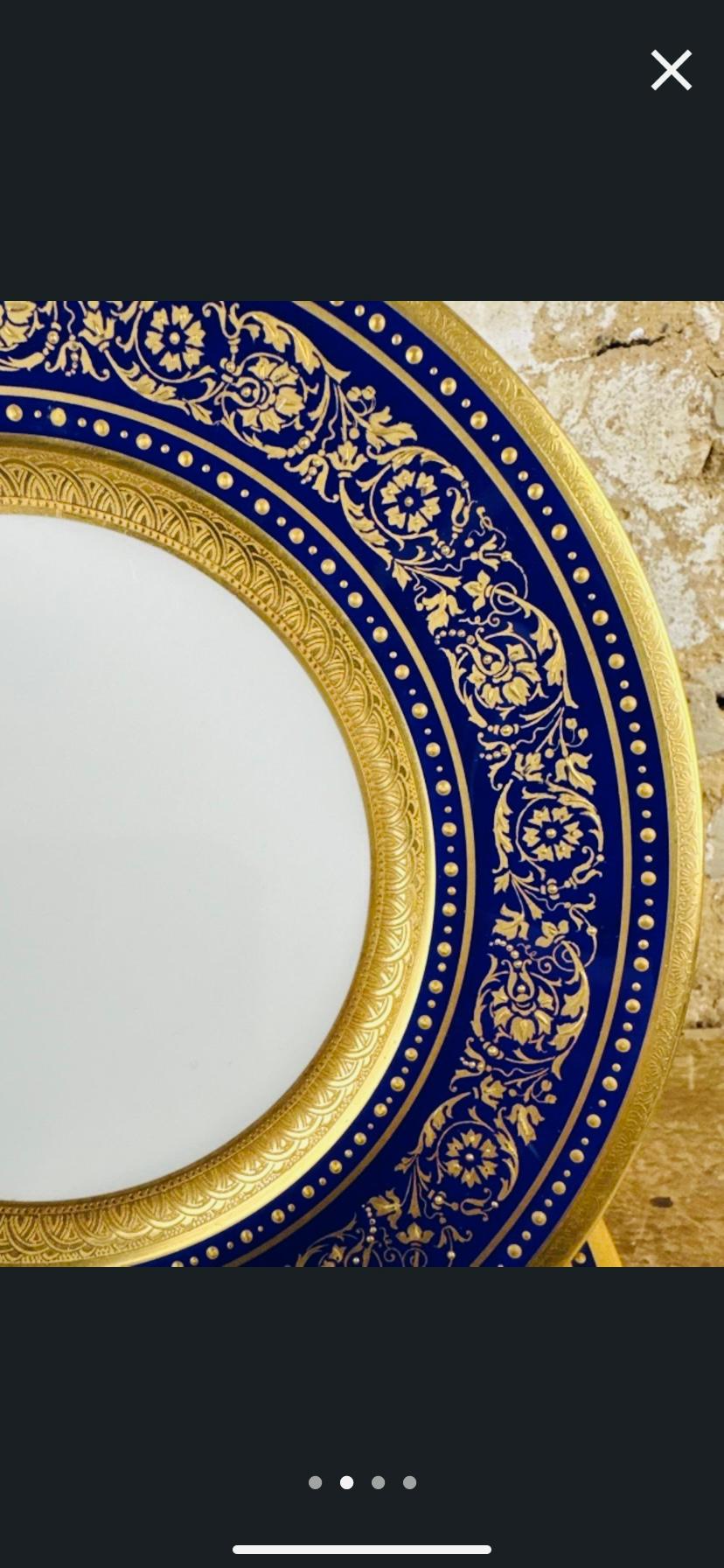 A classic and elegant set of 12 dinner plates with rich cobalt blue collars elaborately decorated in gold in a beaded foliate swag surrounded by two 24 karat gold bands. A nice clear center for food service made with crisp white porcelain. Made by