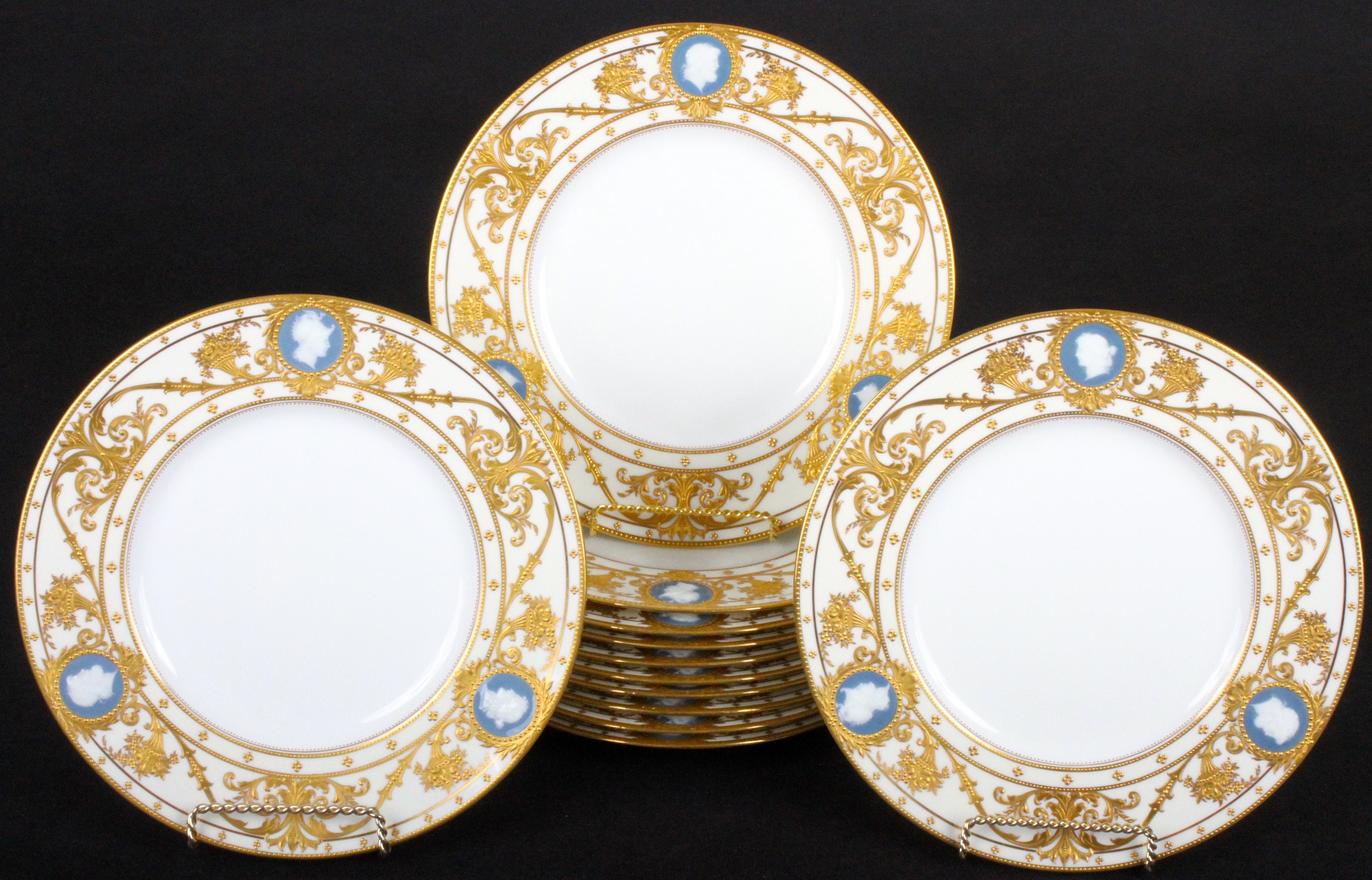 This pristine set of pate-sur-pate service, cabinet or dinner plates features reserves of classical cameo heads and heavy 22-karat raised paste gold gilding. The cameos are composed of white slip set on a blue background, they are ringed by gold