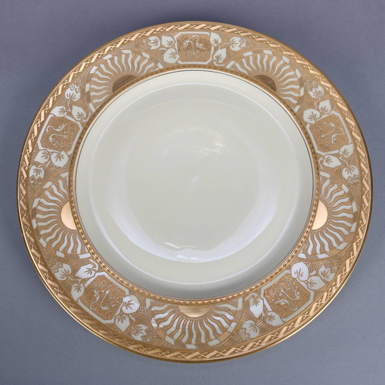 12 Neoclassical Bavarian fine china porcelain dinner plates by Heinrich & Co. feature heavily gold gilt rims with alternating stylized sunsets and reserves of marsh scenes with herons, en verso green crown stamp 