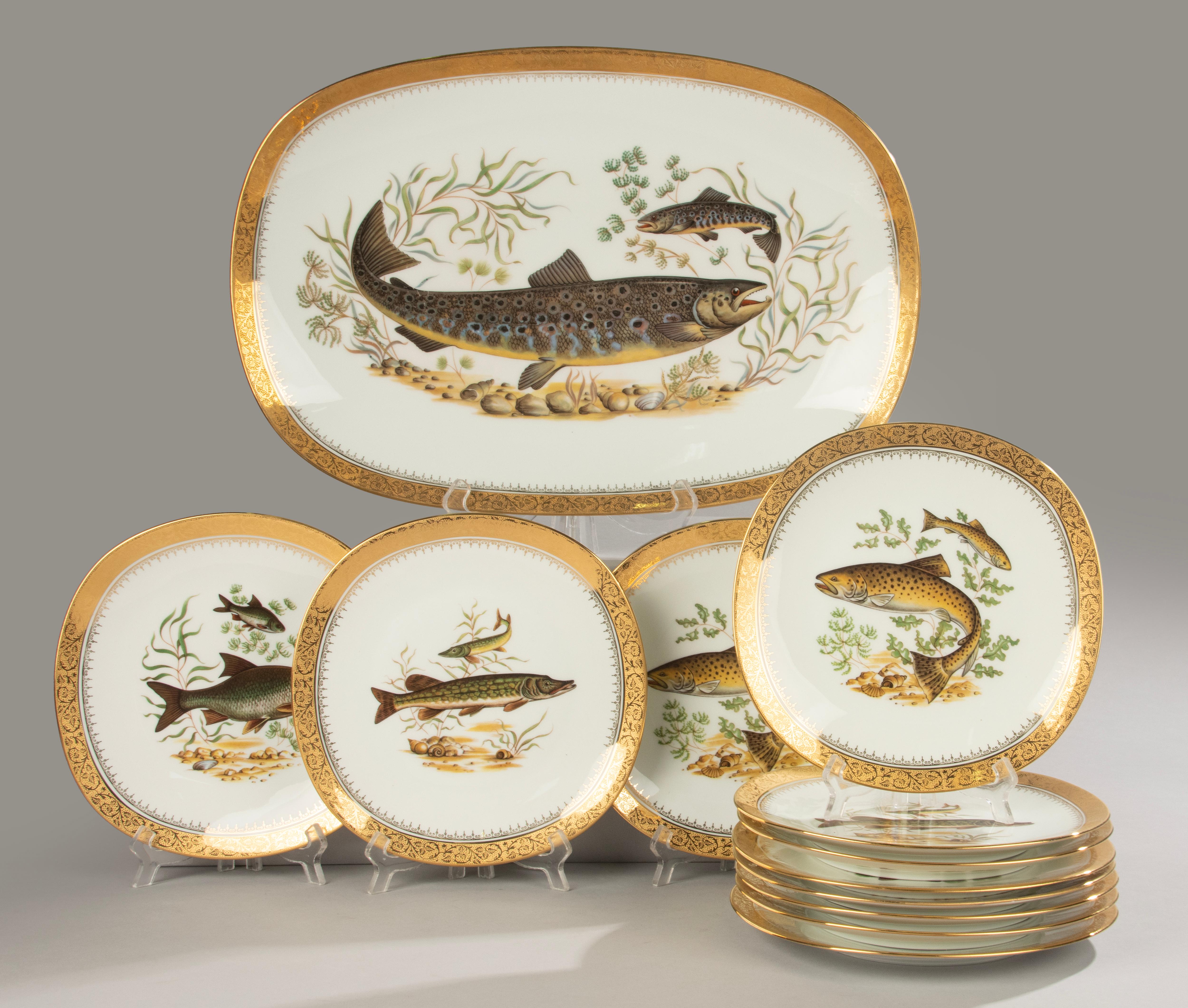 Un magnifique service à poisson en porcelaine par Raynaud, Limoges, France.
Peint à la main (Décor Main) avec des motifs détaillés de poissons d'eau douce, richement décoré avec de l'or 24 carats (Deux Feux or), cuit deux fois et tiré en édition