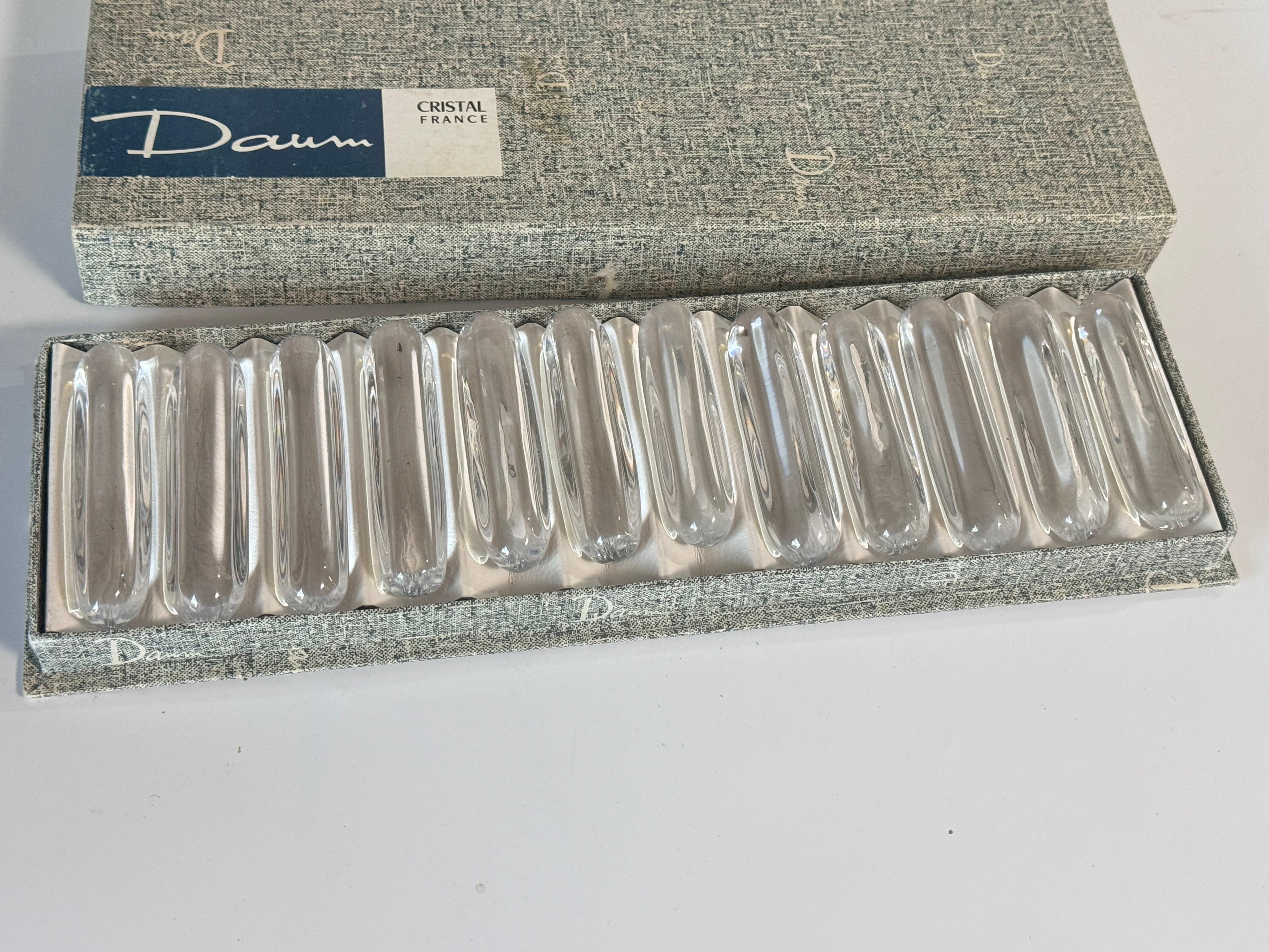 Beautiful set of 12 crystal knife rests from the French brand Daum Nancy. The knife rests have an elegant and simple design, which shows off the quality of the crystal beautifully. It almost looks like drops of water, the crystal is so pure and
