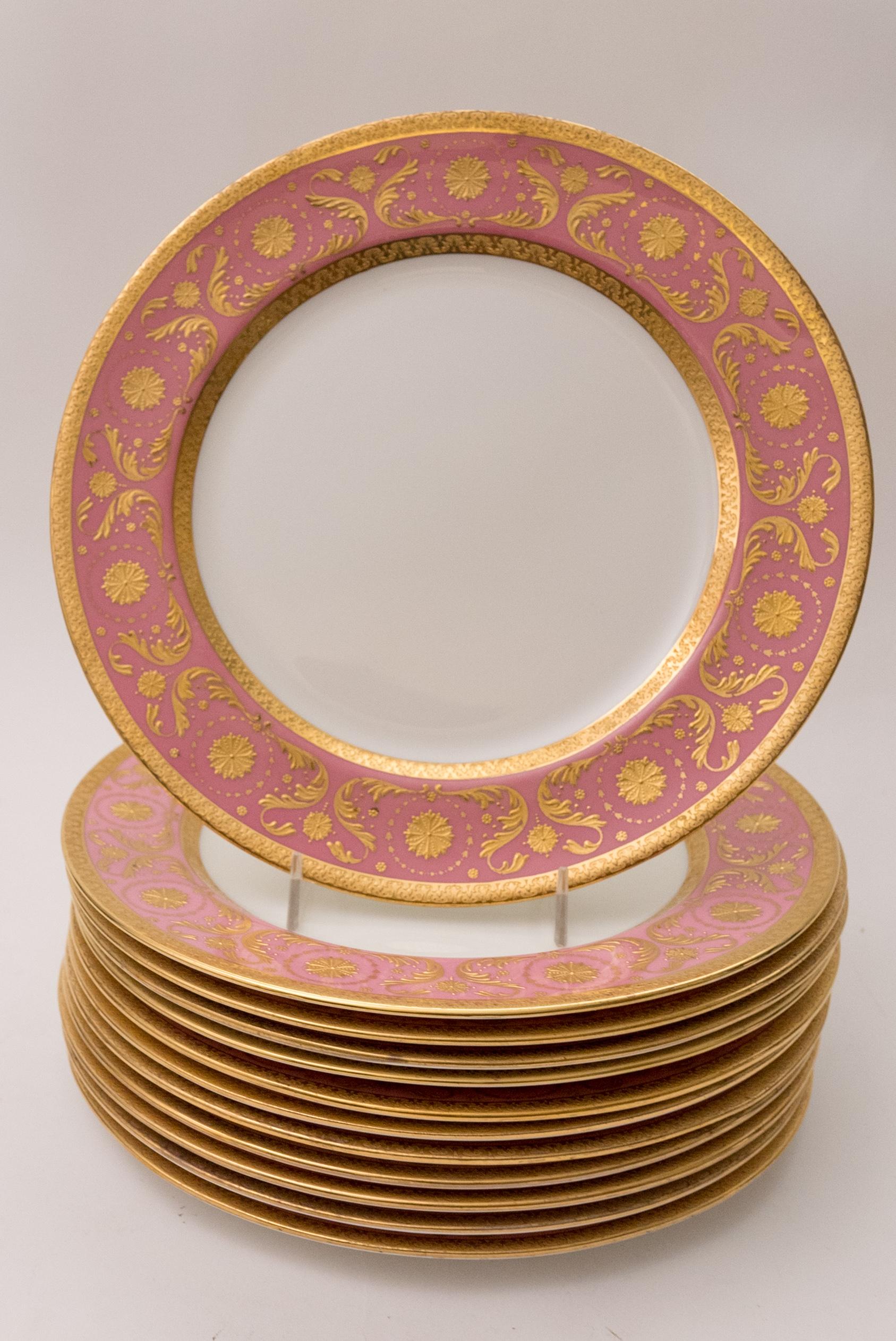 A pretty pink set of twelve dinner plates by one of England's re known firms, Royal Doulton and custom ordered through the fine Gilded Age retailer of Ovington Brothers New York. Lots of great raised paste gilding on their vibrantly colored collars