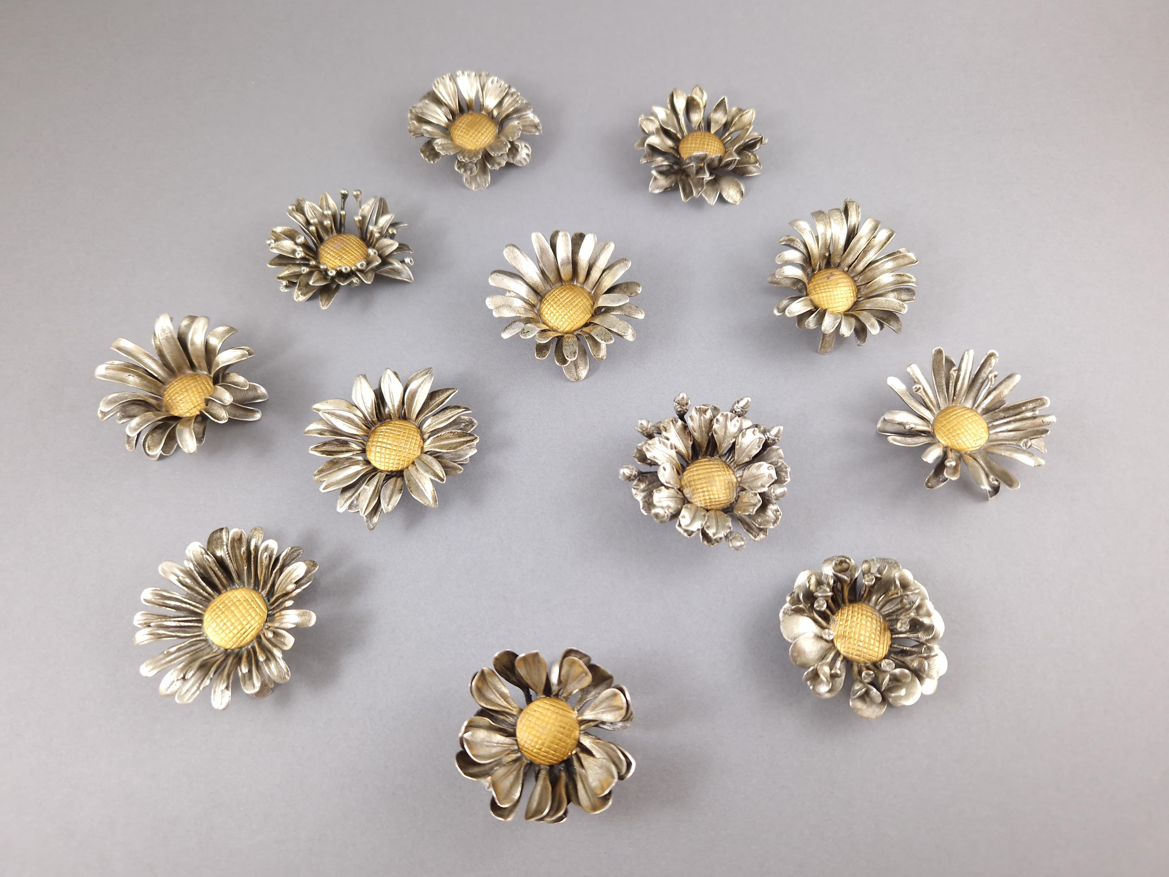 Beautiful set of 12 place card holders or table decorations in solid silver and gilt in the shape of flowers 

800 silver hallmark 
Italian work around 1970 

Height: 2 cm 
Diameter between 4.2 and 5 cm 
Weight: 395 grams

Great condition.