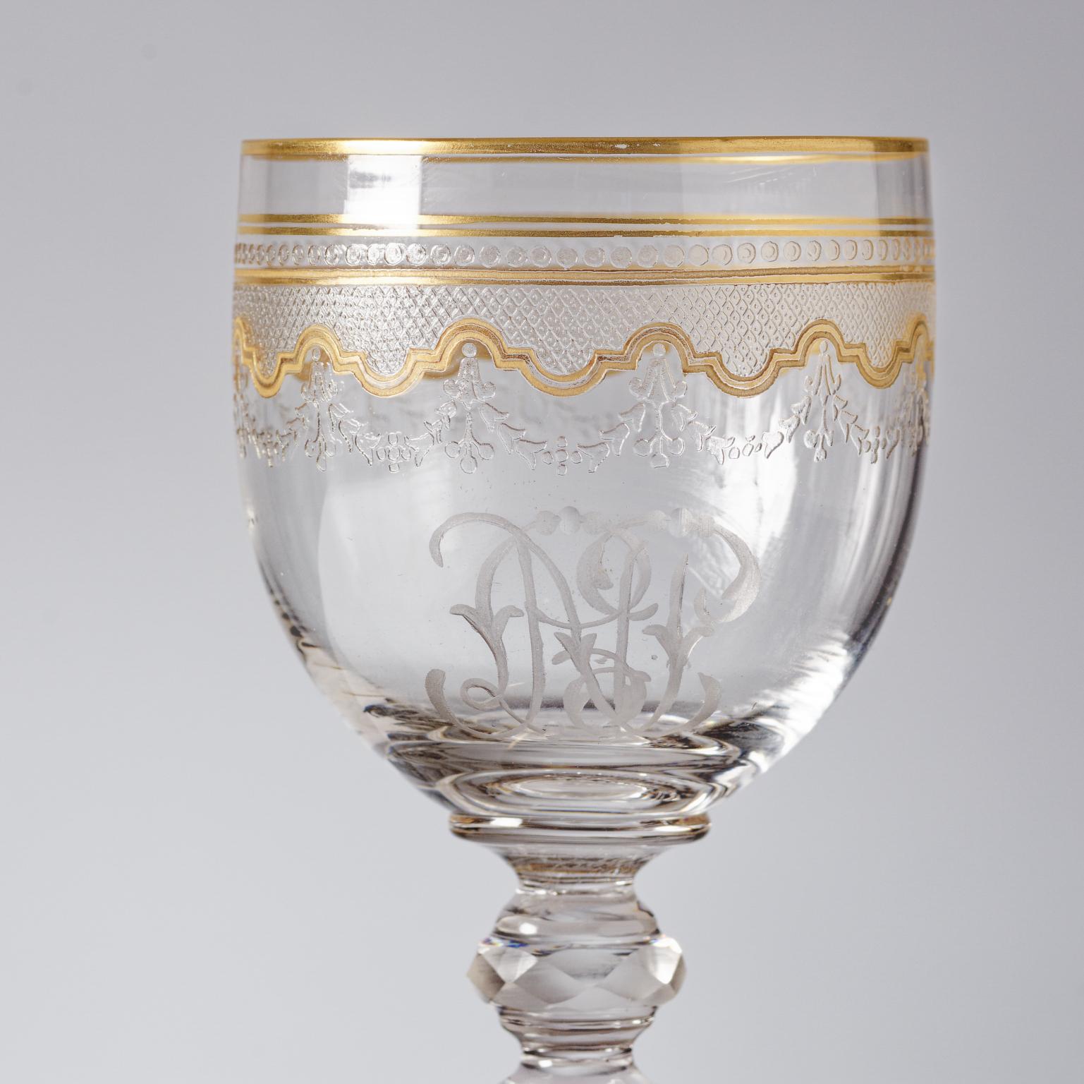 An elegant set of wine or liqueur glasses by the re known cristallerie firm of Saint Louis France. This pattern features a nice cut knob stem and shaped gilt design surround on the top portion of the rim enhanced with cut fan diamonds and floral