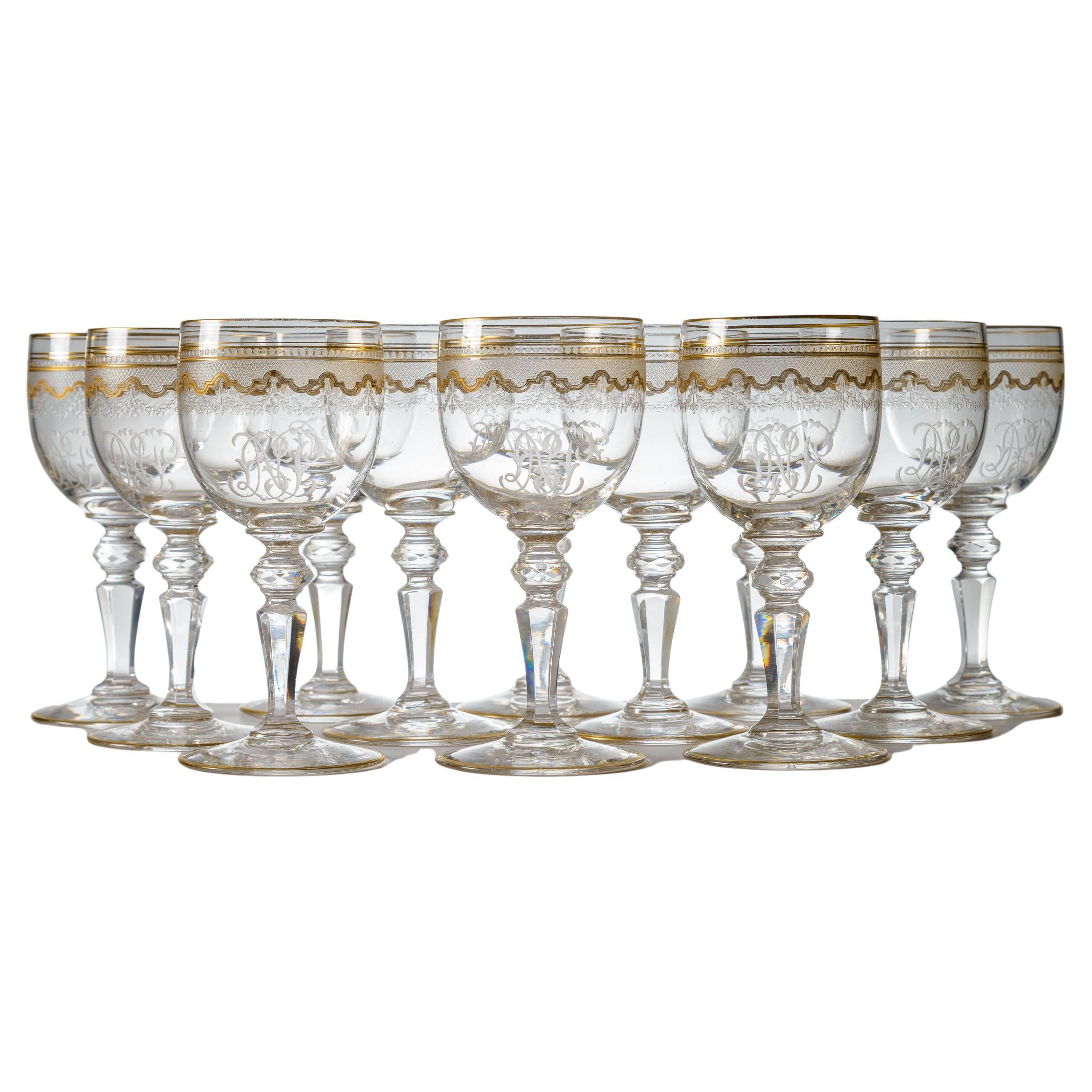 12 verres à vin décorés de dorures de Saint Louis avec tiges à nœud taillé, antique