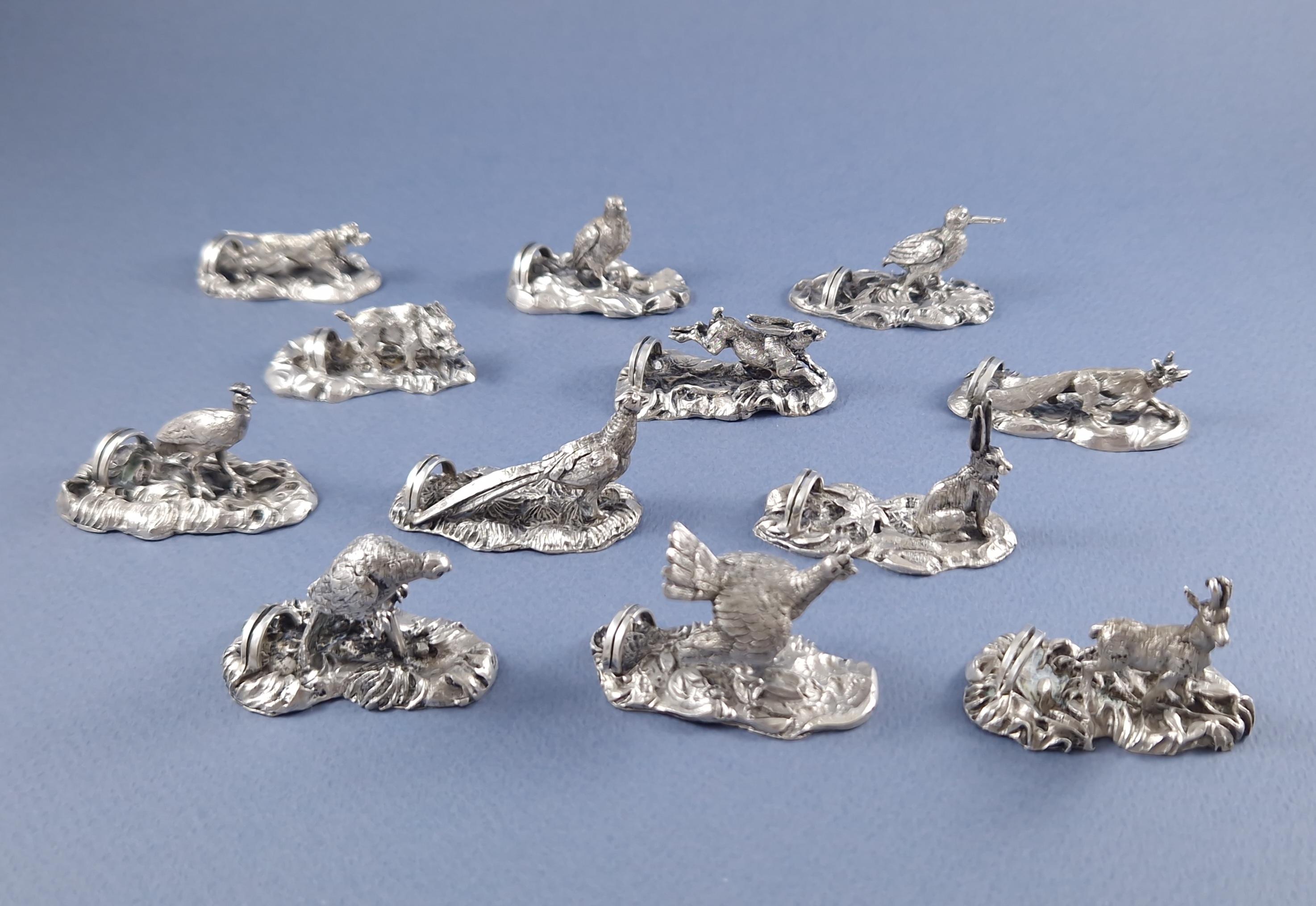 Beautiful set of 12 place cards holder or menu in solid silver 
In the shape of finely chiseled natural animals 

Silver hallmark 800 
Length between 4.6 and 5 cm 
Height between 1.7 and 3.5 cm 
Weight: 304 grams 
In its original box

Great condition