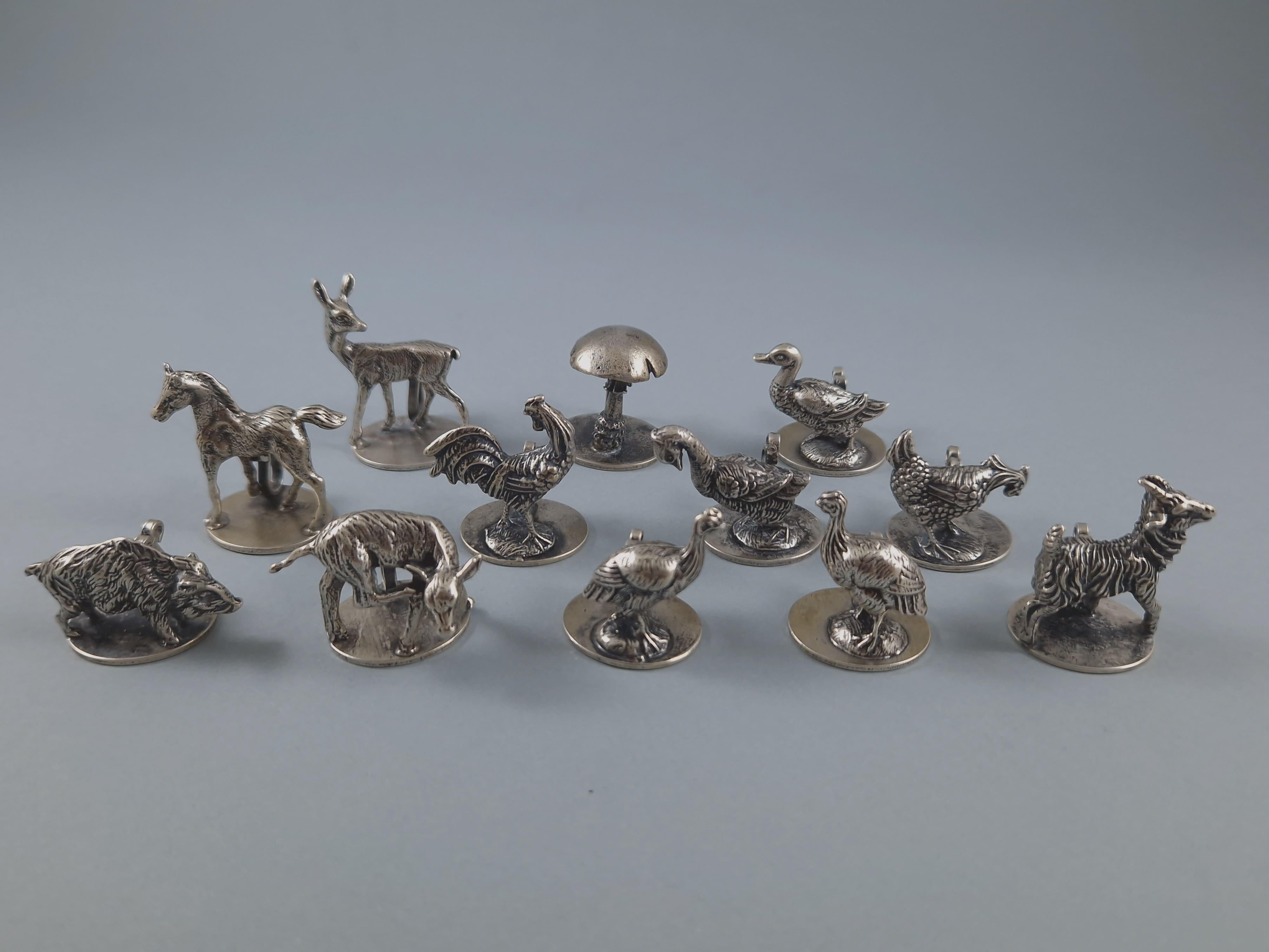 Beautiful setof 12 place cards holders in solid silver 

In the shape of finely chiseled animals and a mushroom 

Height between 2.5 and 3.8 cm 
Weight: 257 grams