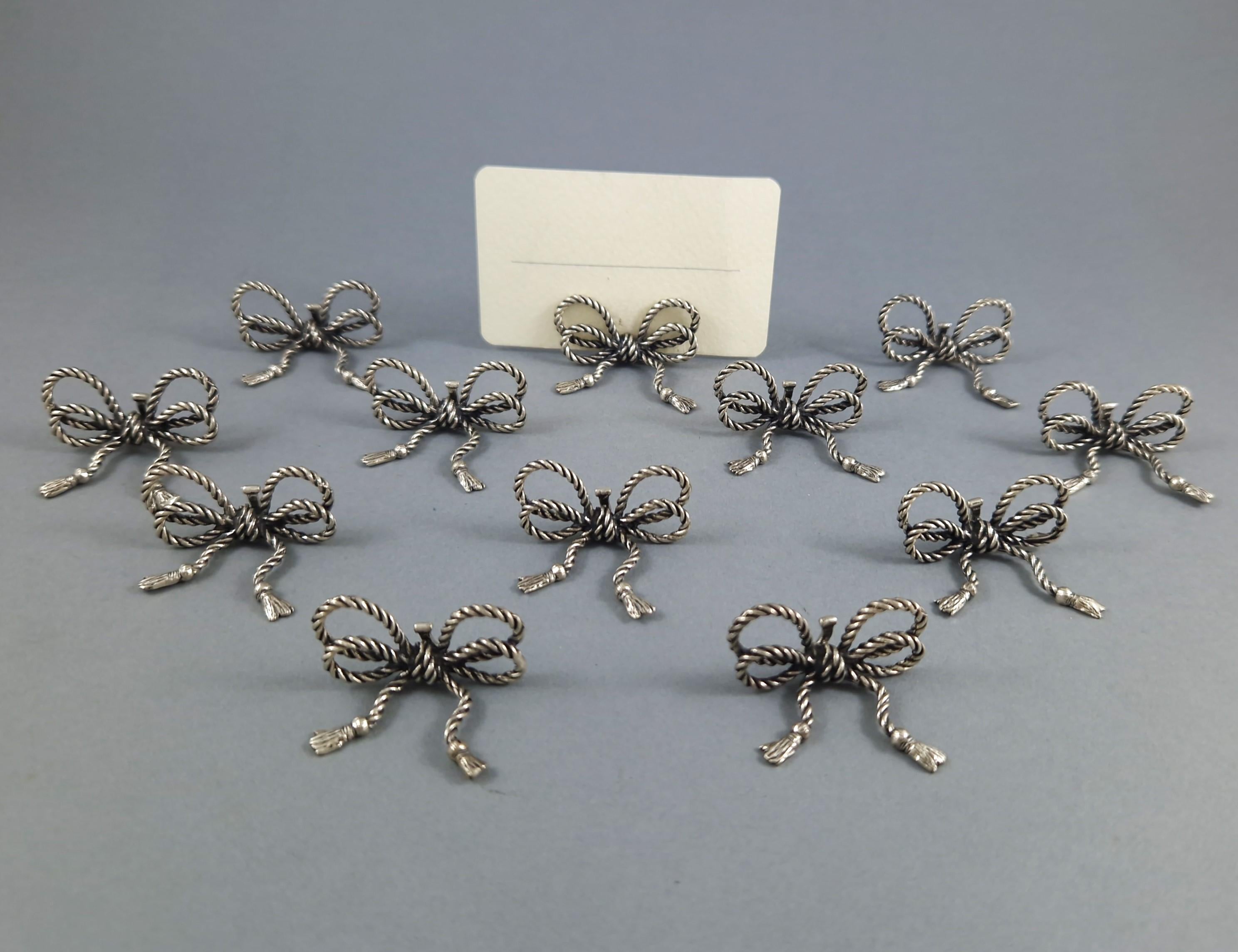 12 segnaposto a forma di fiocco in argento sterling. Opera italiana, circa 1970.
Lunghezza: 3,5 cm; larghezza: 3 cm; altezza: 1,6 cm; peso totale: 80 grammi.
Argento con marchio 800.