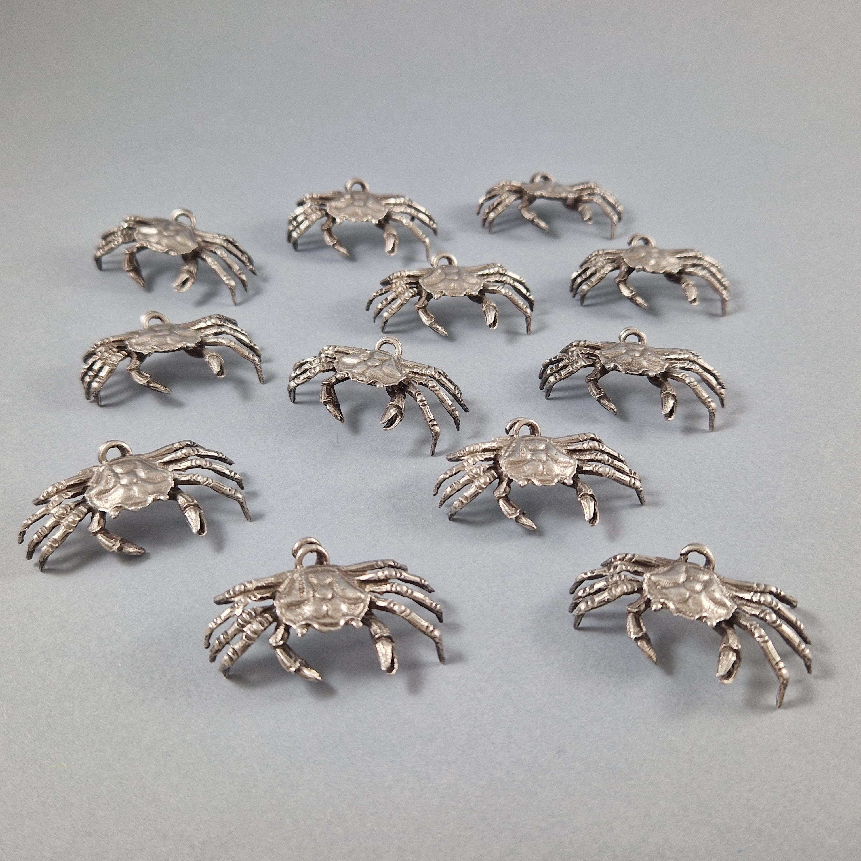 Beautiful set of 12 place cards holders holders in Sterling Silver 

In the shape of crabs finely chiseled in the natural

925 silver hallmark 
Silversmith: Fratelli Cacchione 
Length: 4.5 cm 
Width: 2.7 cm 
Height: 1.4 cm 
Weight: 155 grams