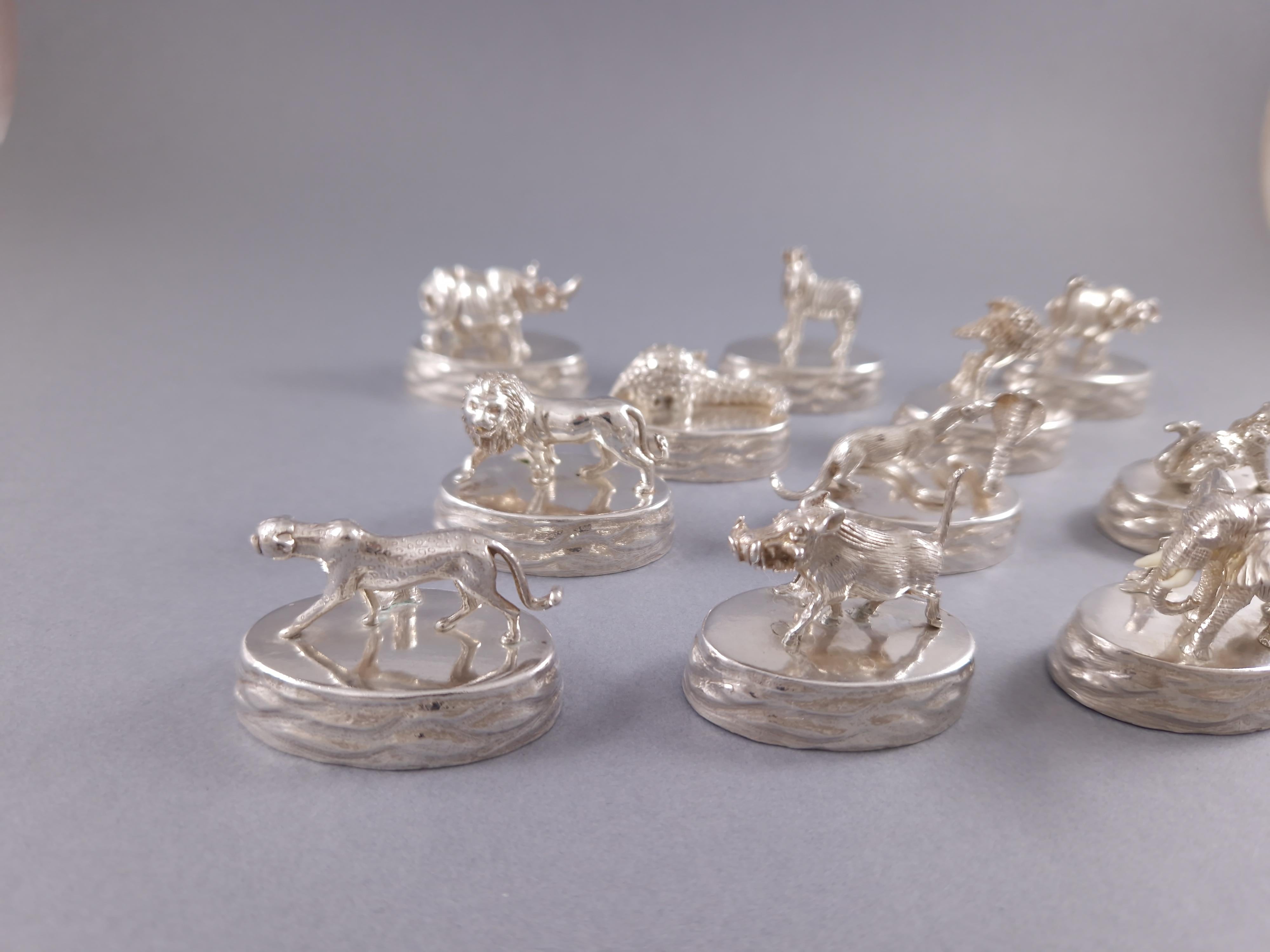 Beautiful set of twelve sterling silver place card holders representing finely chiseled savannah animals 
Silversmith's mark PM for Patrick Marvos 
Silver hallmark 
Length: 4.2 cm 
Width: 2.5 cm 
Height between 2.4 and 4 cm 
Weight: 390 grams