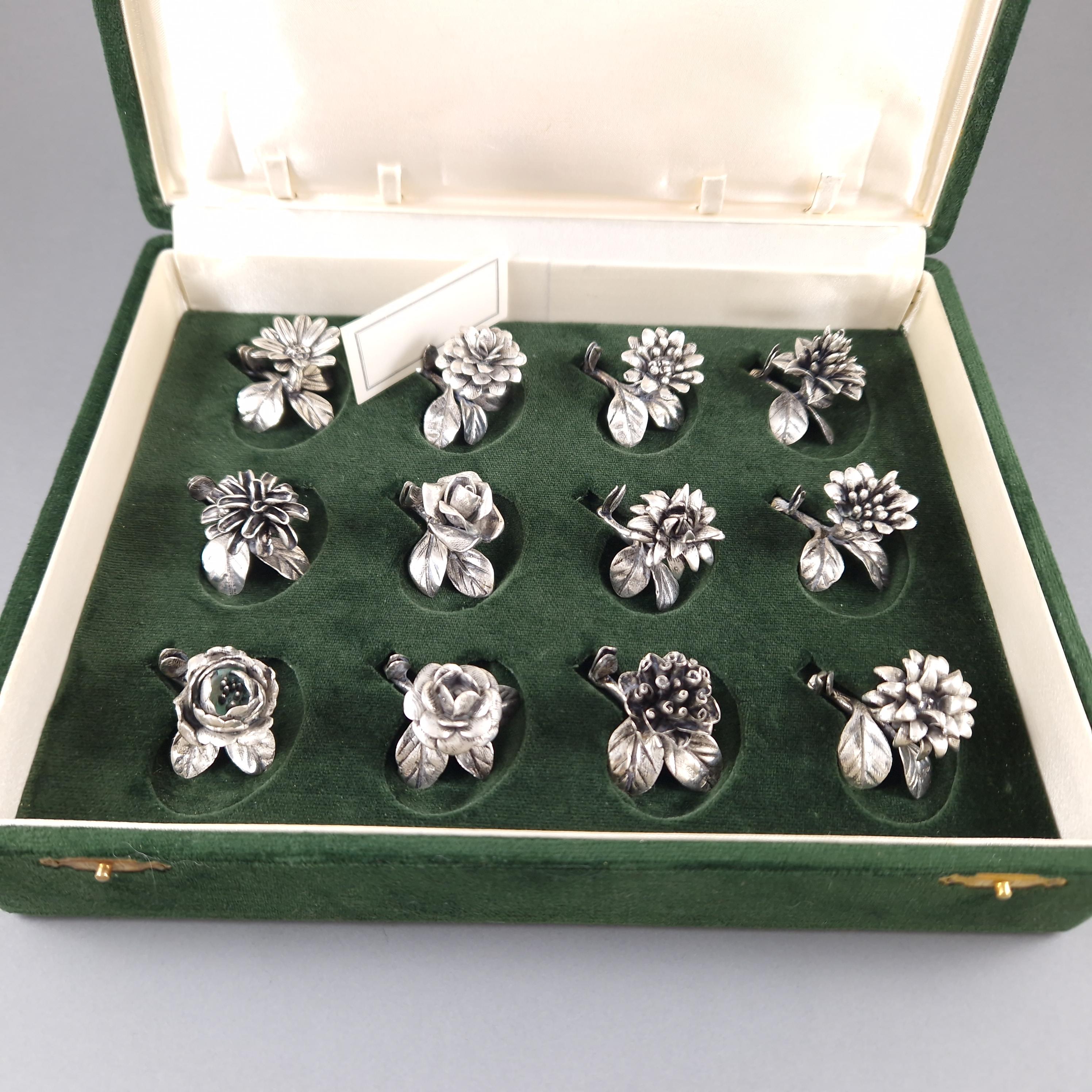 Beautiful set of 12 Sterling Silver Place Card Holders in the shape of flowers 
Hallmarked 800 silver 
Silvermith: Bartolini Bartolozzi 
Height between 2.5 and 3.2 cm 
Length: 3.5 cm 
Weight: 221 grams 
In its original box