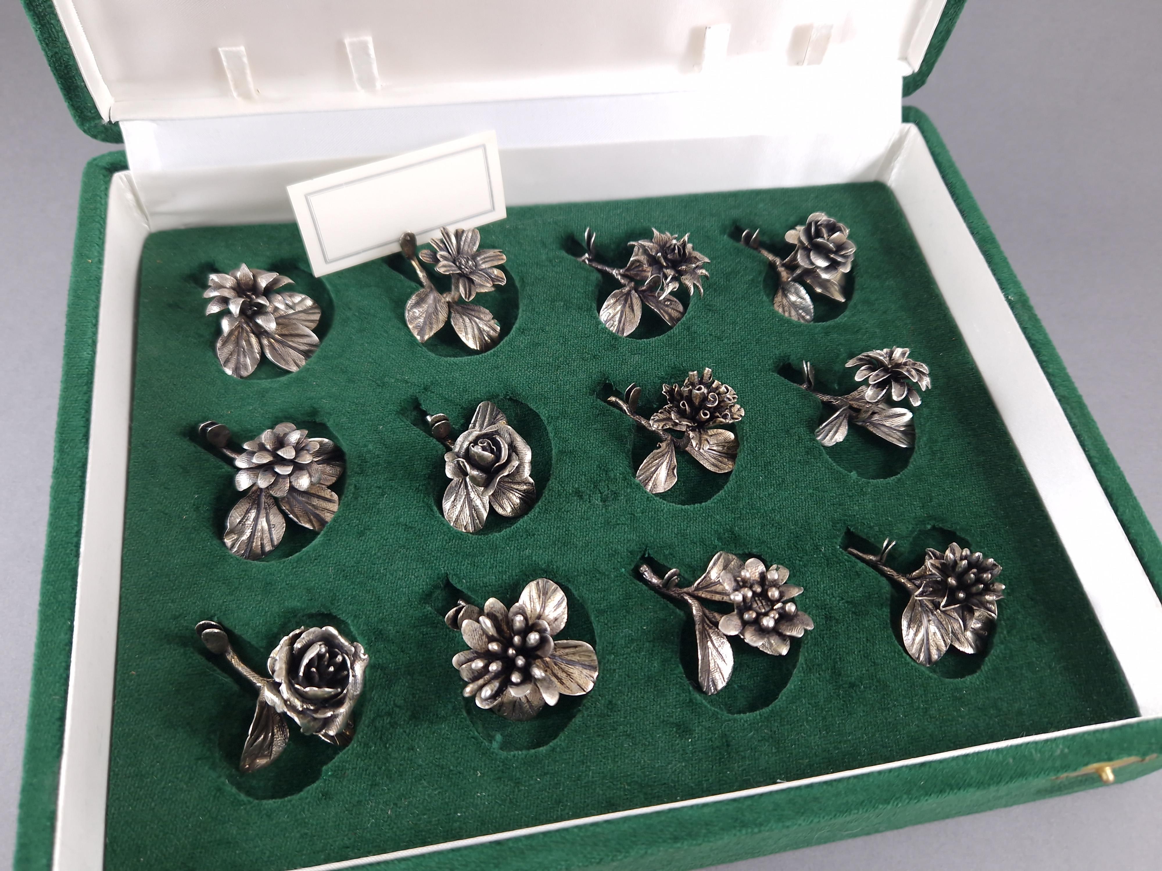 Beautiful set of 12 Sterling Silver Place Card Holders in the shape of flowers 
Hallmarked 800 silver 
Silvermith: Bartolini Bartolozzi 
Height between 2.5 and 3.2 cm 
Length: 4.2 cm 
Weight: 140 grams 
In its original box