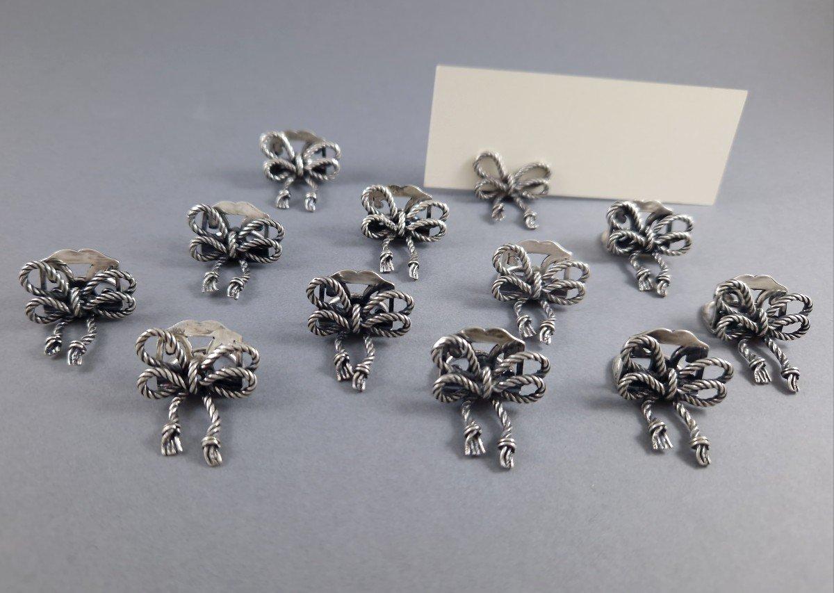 Set di 12 portabiglietti da visita in argento a forma di nodo 
Opera italiana del 1970 circa 
Punzone d'argento 925 
Altezza: 1.4 cm 
Lunghezza: 2.5 cm 
Peso: 913 grammi