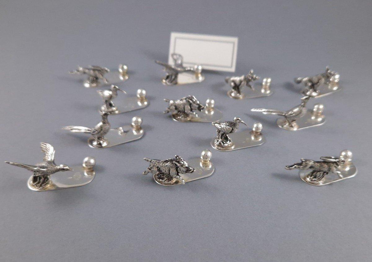 Juego de doce portavasos de plata de ley sobre el tema de la caza

Sello de plata 800 
Obra italiana de mediados del siglo XX

Longitud: entre 3,4 y 5 cm
Altura: entre 1,5 y 2,5 cm
Peso: 166 gramos