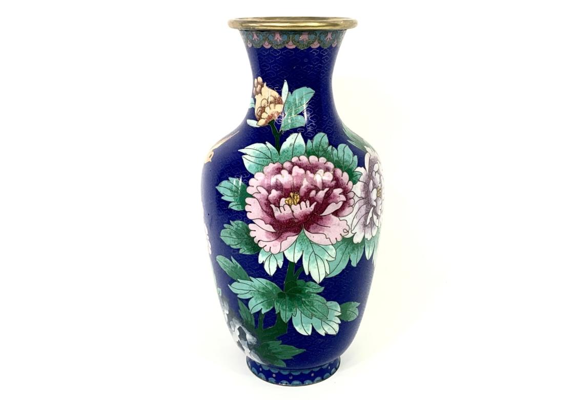 Cloisionne Vase mit blauem Grund mit Pfingstrosen, Blättern und einem Vogel. Der blaue Grund ist mit einem Feld aus abstrakten Messingmotiven verziert.

Abmessungen: 5 1/2