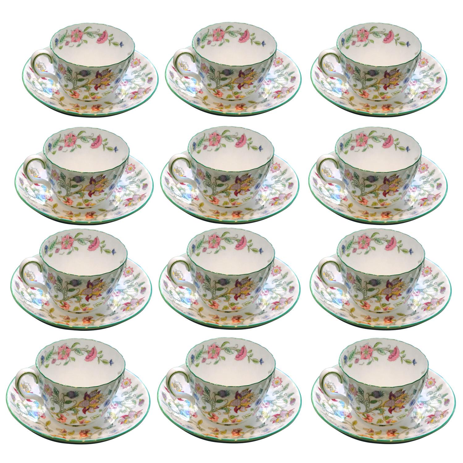 Ensemble de 12 tasses à thé et avec leurs soucoupes en porcelaine Bone China de Minton. Célèbre modèle Minton Haddon Hall conçu par John William Wadsworth (1879-1955), reconnaissable à son corps cannelé et à son fond blanc décoré de fleurs colorées