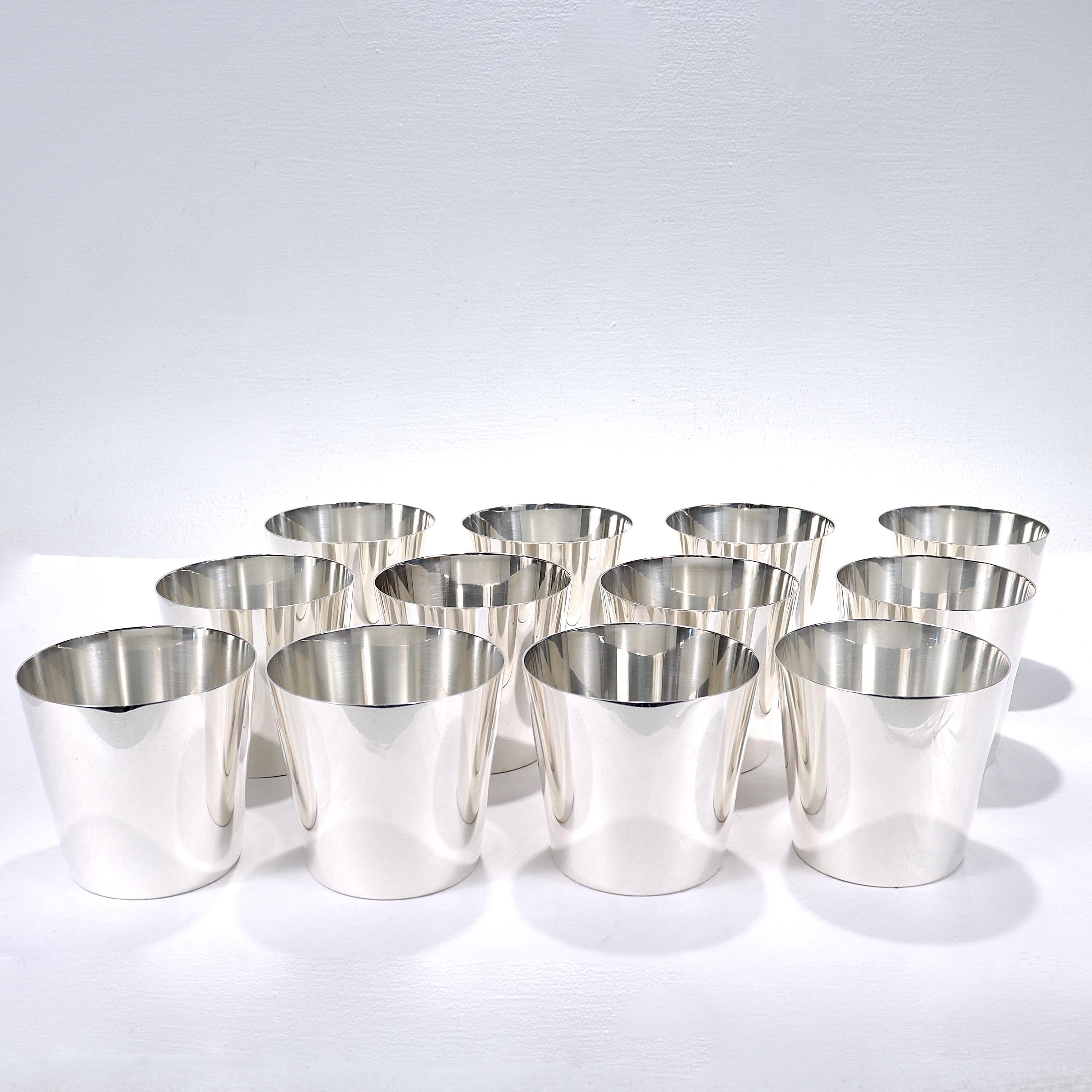 A fine set of 12 cocktail tumblers or cups with straight, clean Modern lines.

By Tiffany & Co.

In sterling silver. 

Each marked to the base with Tiffany & Co. / Maker's / Sterling Silver / 77588.

Simply a top-level, hard to find set tumblers