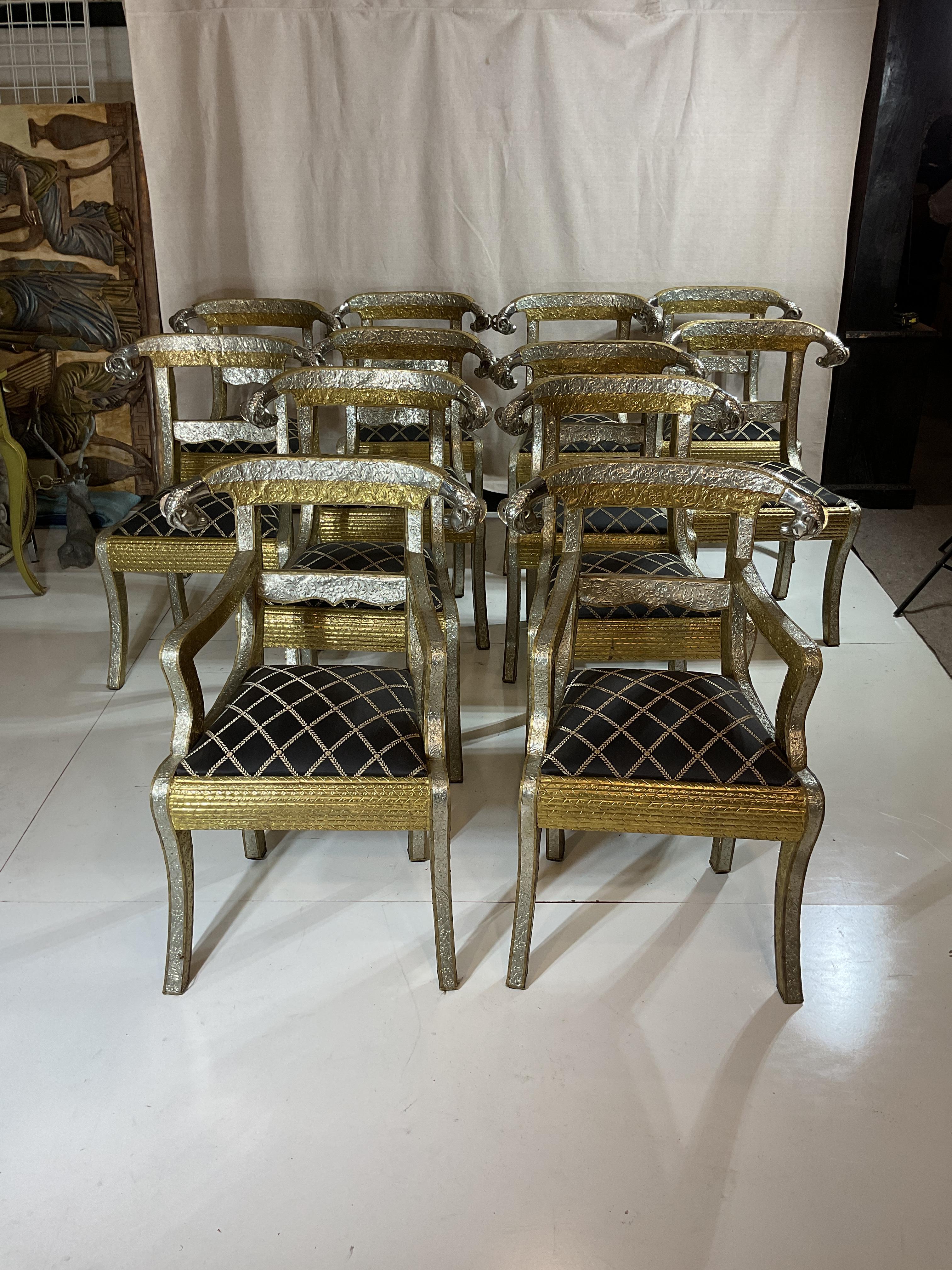 Set of 12 vintage Anglo-Indian rams head chairs
2 arm chairs and 10 side chars
Nickel plated in gold and silver coloration 
Embossed with beautiful intricate detail
Pair of ram heads on each chair 
Made in India
Rare two toned set including unusual