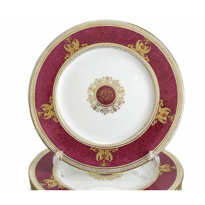 12 Wedgwood Porcelain dinner plates in Columbia Raised Gilt & Powder Red #W1579

10 Wedgwood porcelain dinner pates in Columbia Powder Red #W1579. A powdered red design pattern rim and to the center. Hand painted gilt accents with pairs of gilt